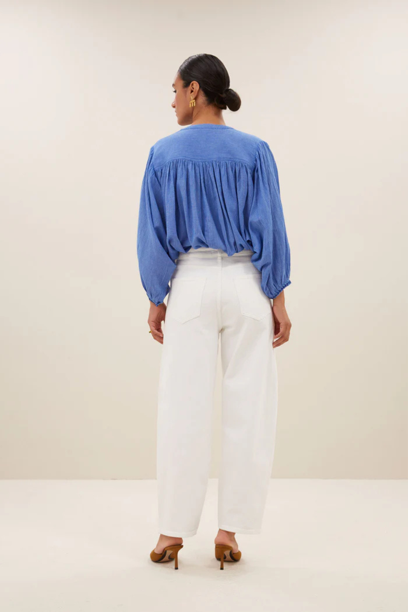 Model wearing the By-Bar becky athia blouse in sapphire blue. Back view