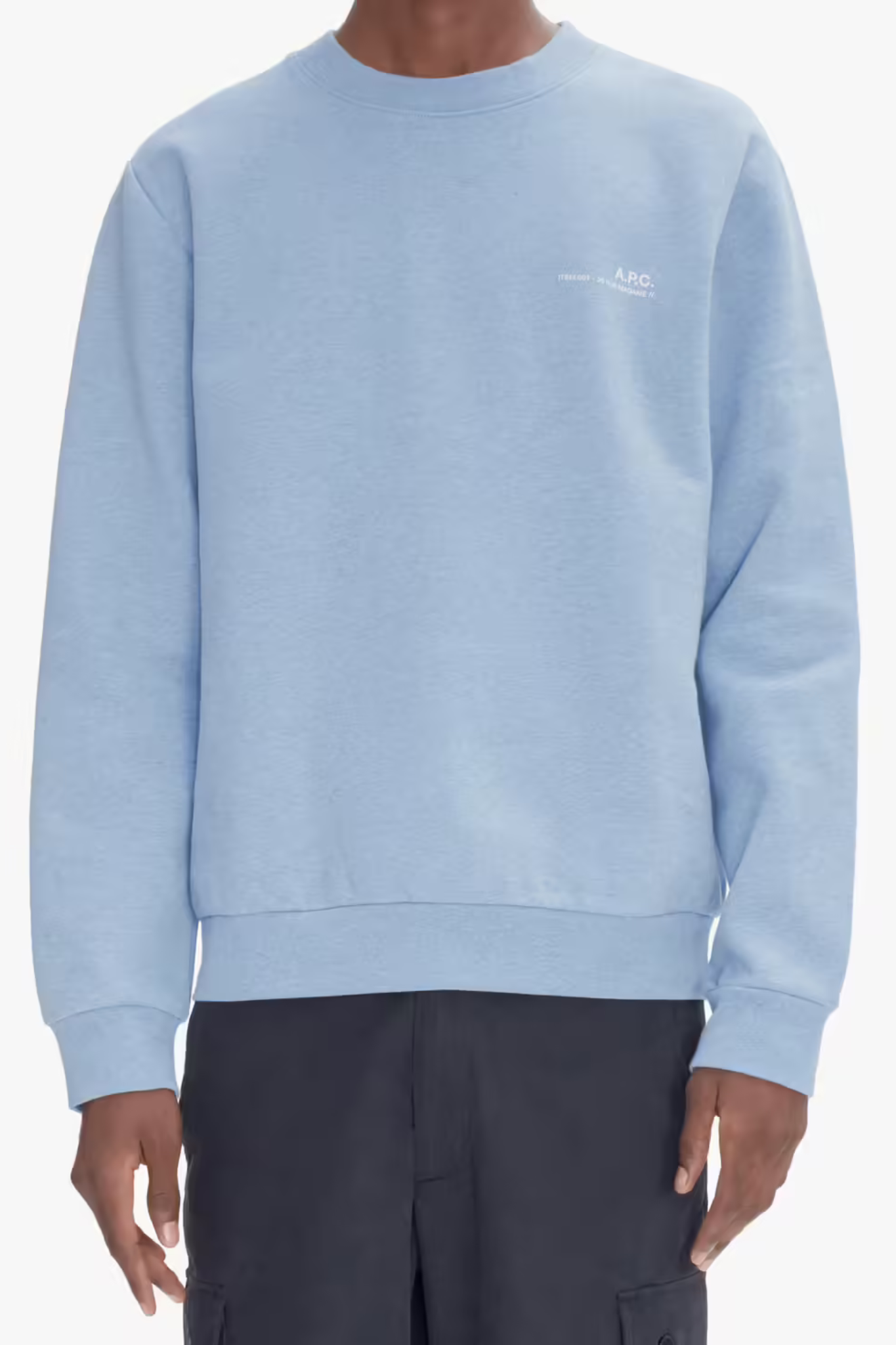 Model wearing the APC overdye sweatshirt in light blue with logo in ecru. Front view