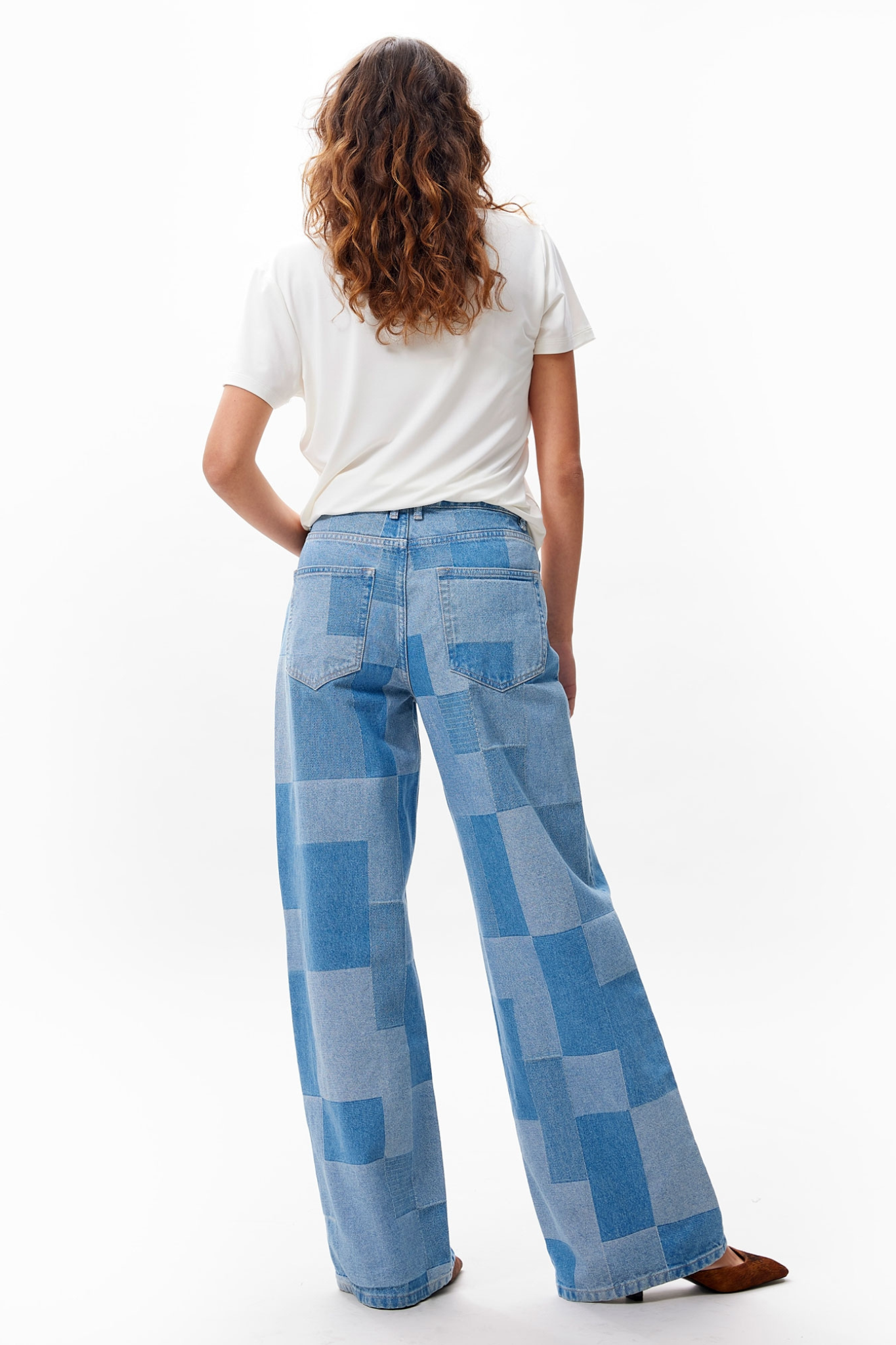 Model wearing the Catwalk Junkie patchwork loose fit jeans in blue. Back view