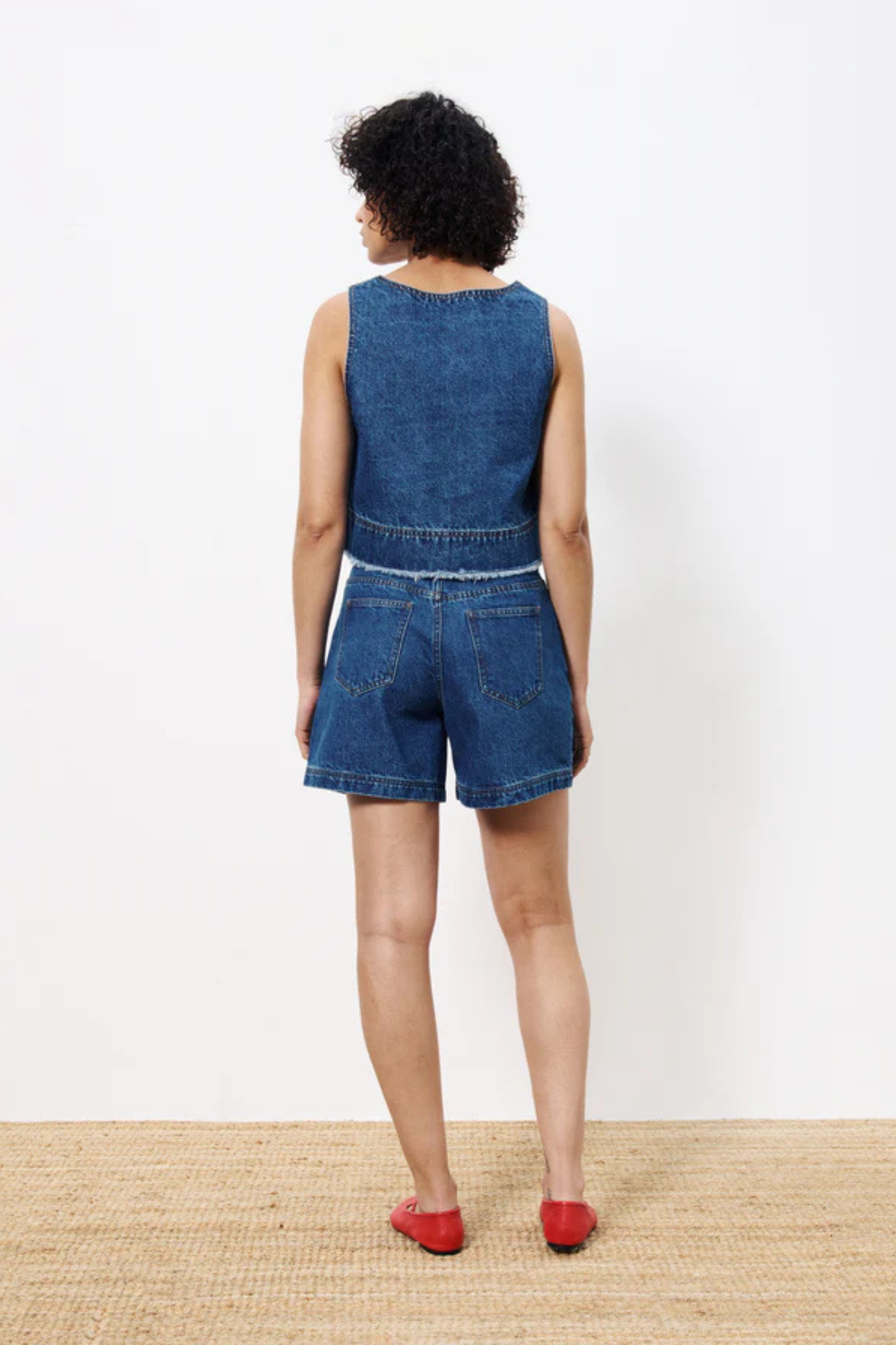 Model wearing the FRNCH dafne top in denim blue. Back view