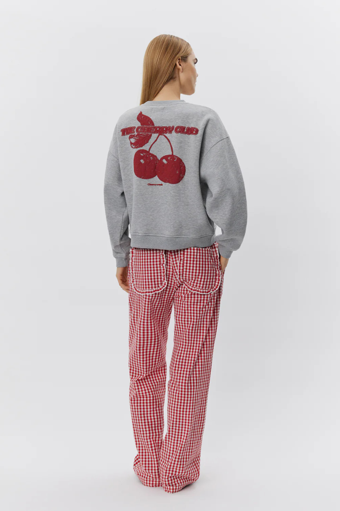 Model wearing the Sofie Schnoor elis sweatshirt in grey melange and cherry graphic in red. Back view