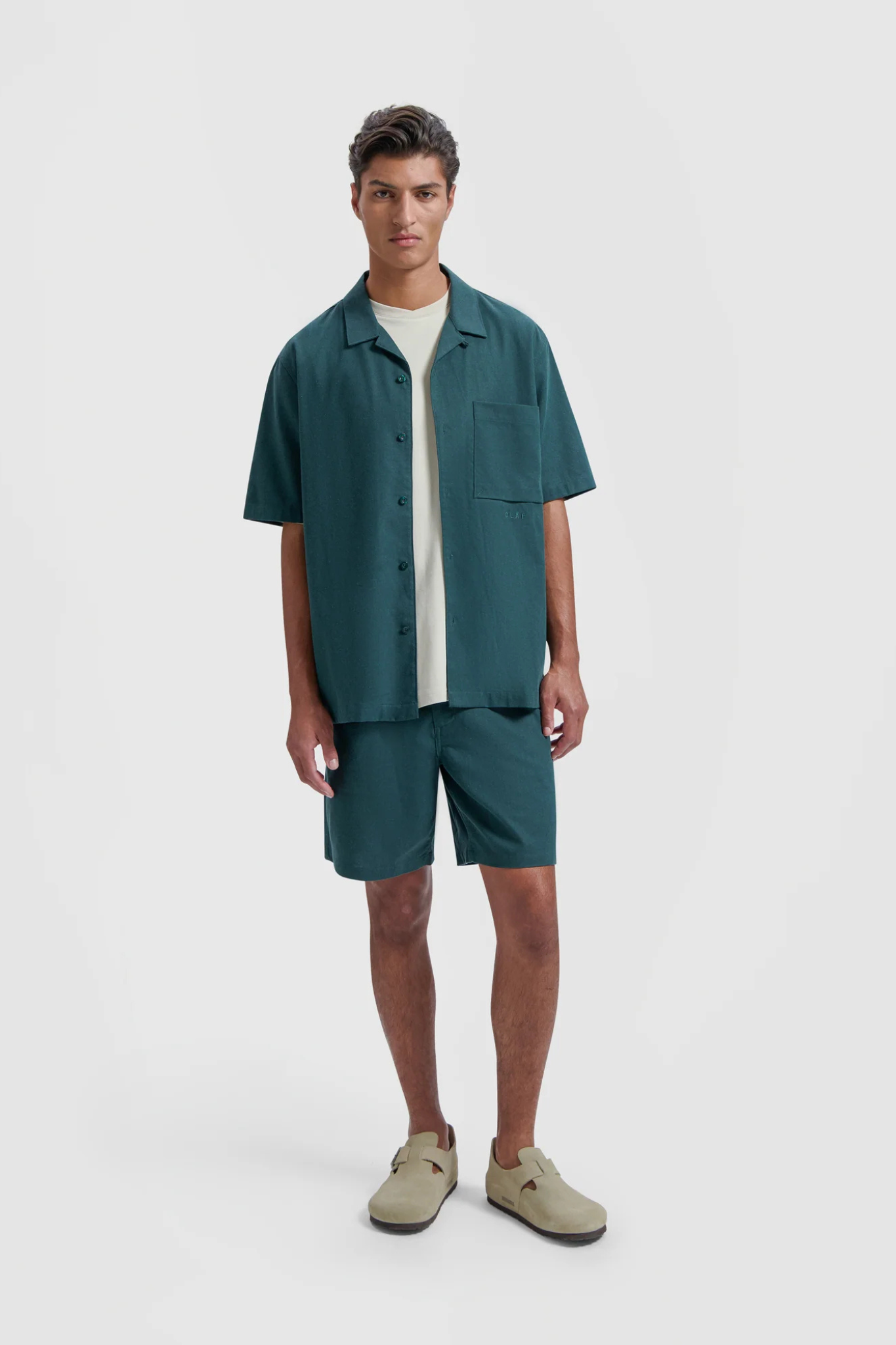 Model wearing the Olaf linen shorts in dark green. Front view