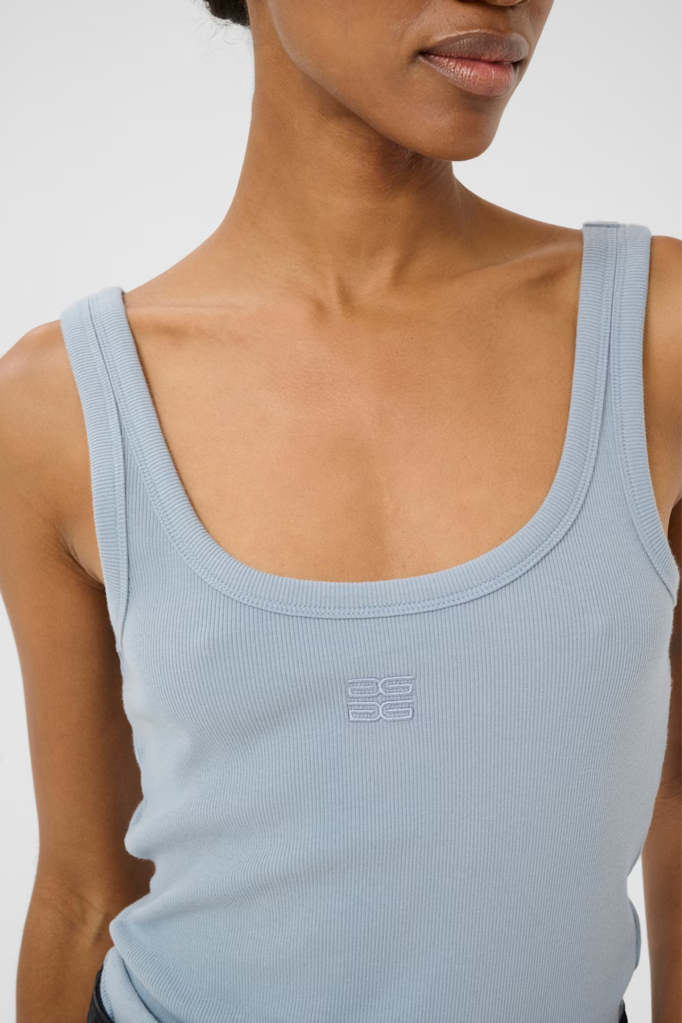 Model wearing the Gestuz drew logo top in grey blue. Front view