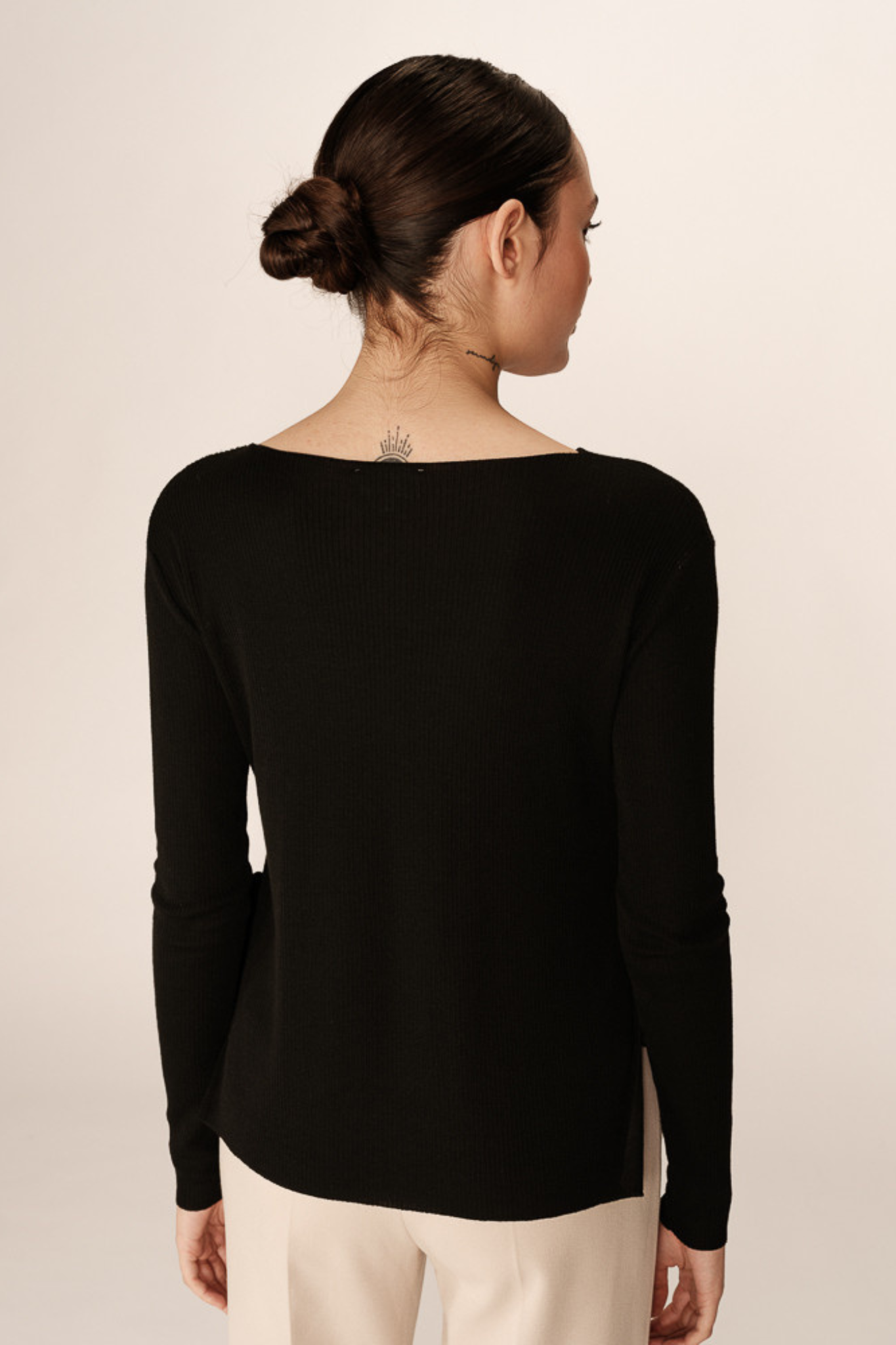 Model wearing the Grace & Mila palmer sweater in black. Back view