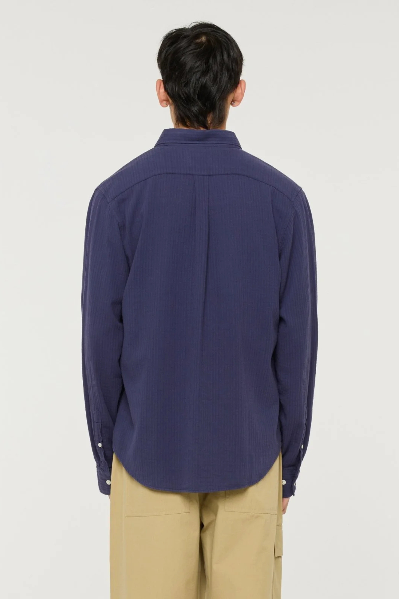 Model wearing the Castart konga shirt in navy. Back view