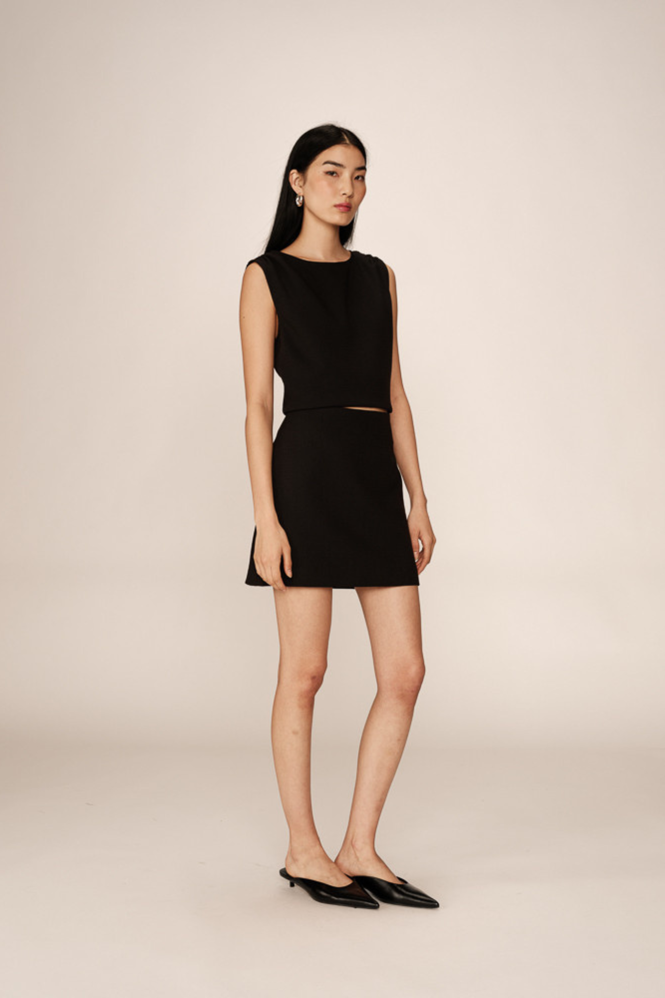 Model wearing the Grace & Mila pekin mini skirt in black. Front view