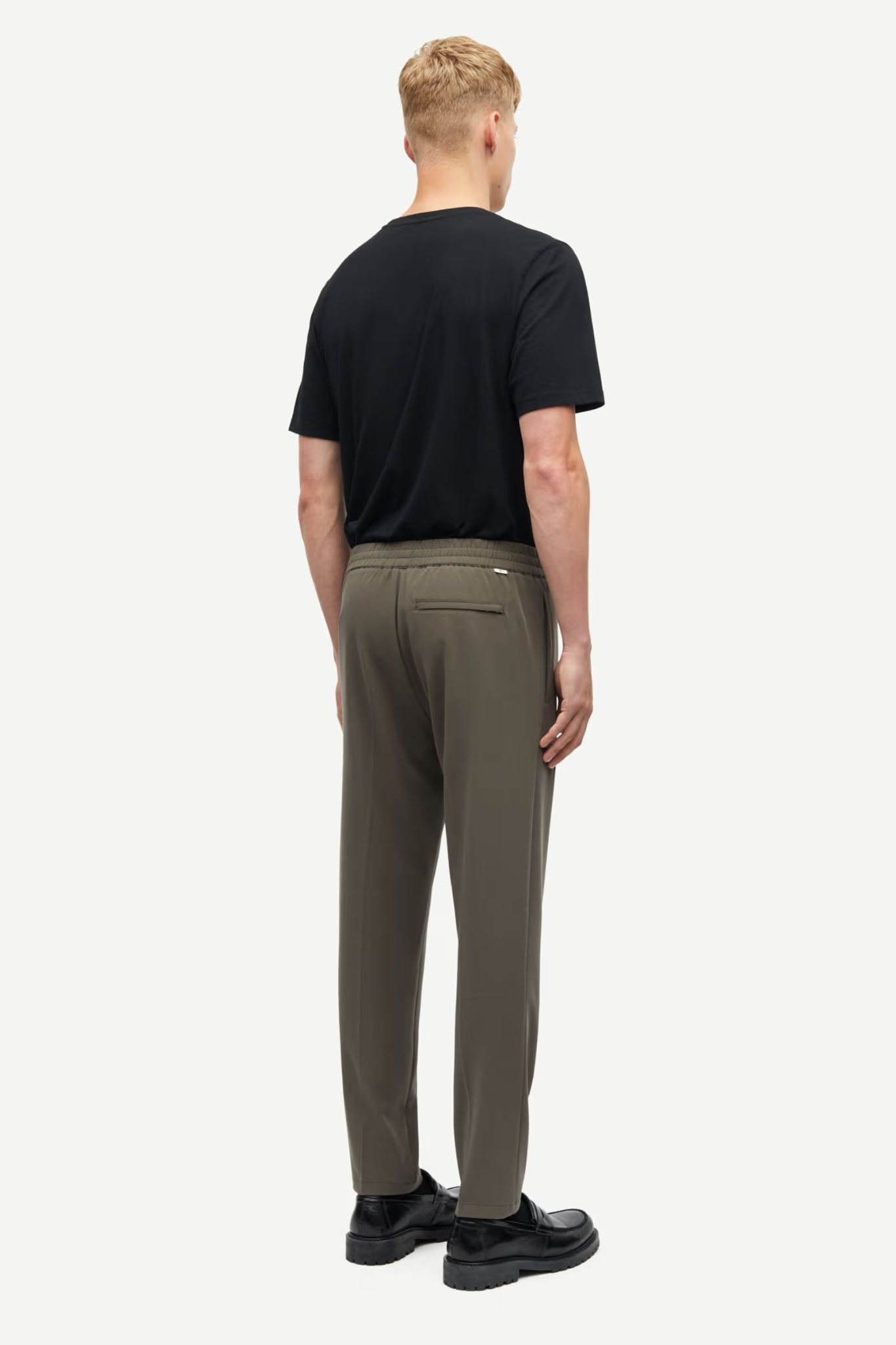 Model wearing the Samsoe Samsoe smithy trousers in khaki. Back view