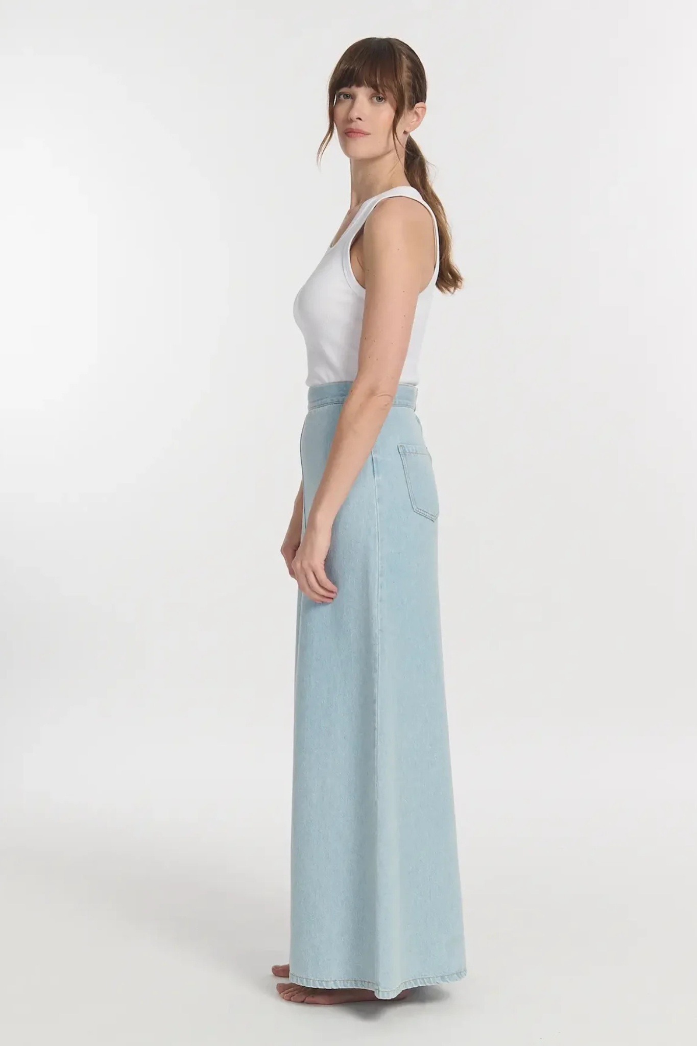 Model wearing the Labdip jodie denim tencel skirt in bleached denim. Side view