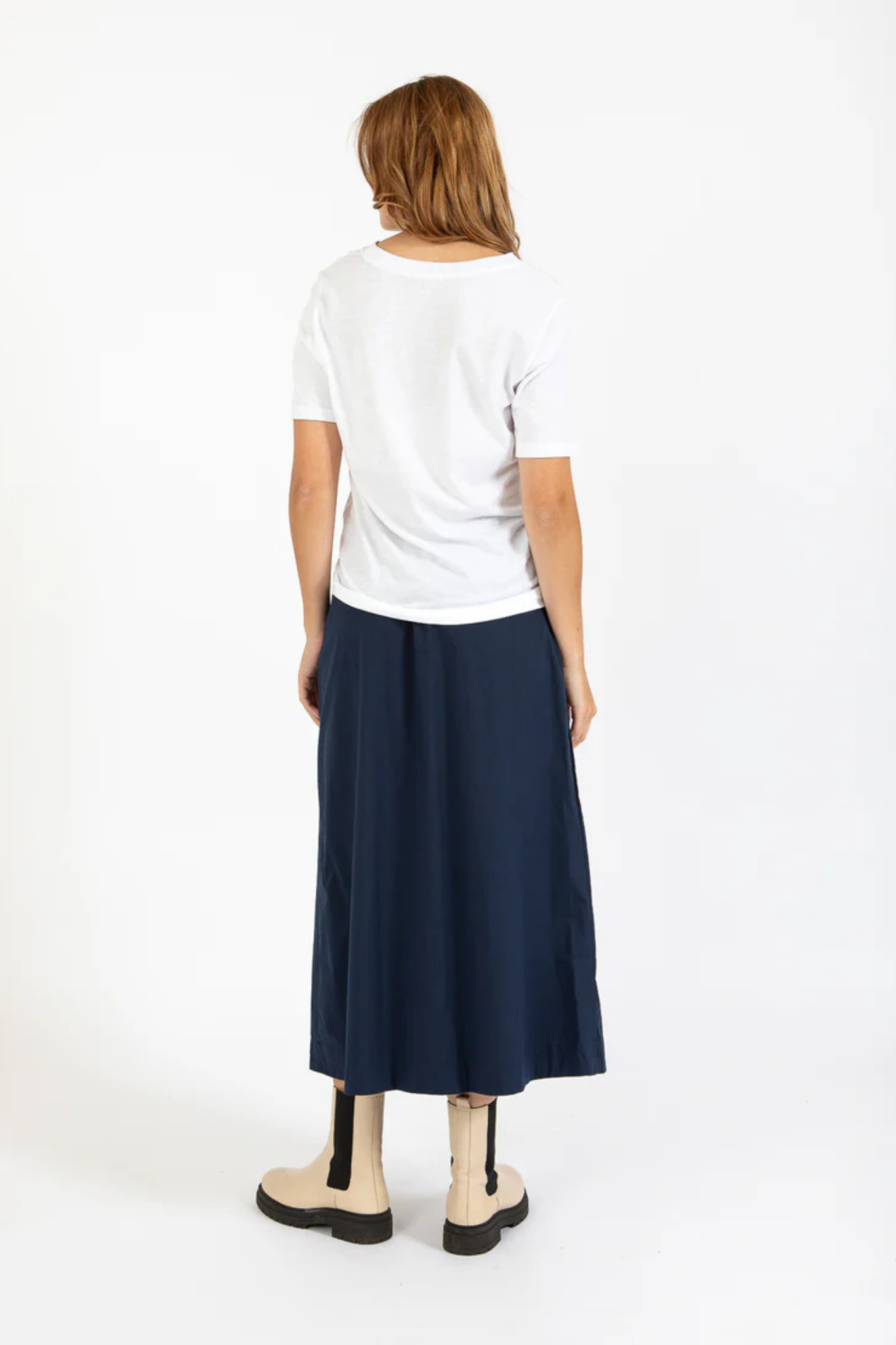 Model wearing the CC heart Phoebe long skirt in navy. Back view