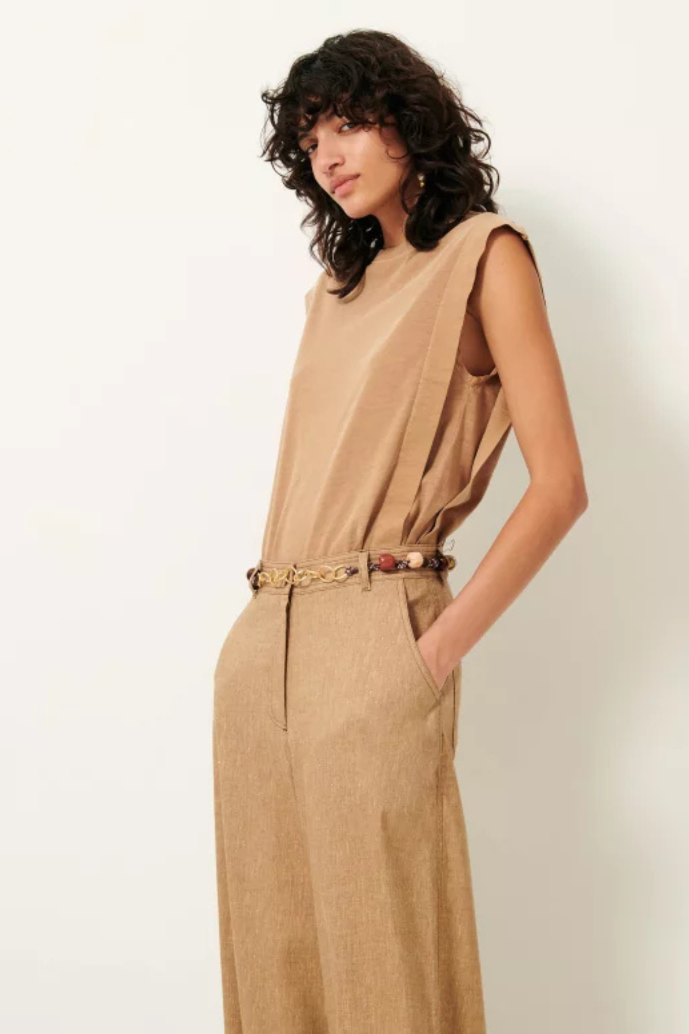 Model wearing the Sessun orlando pleated sleeveless t-shirt in camel. Side view