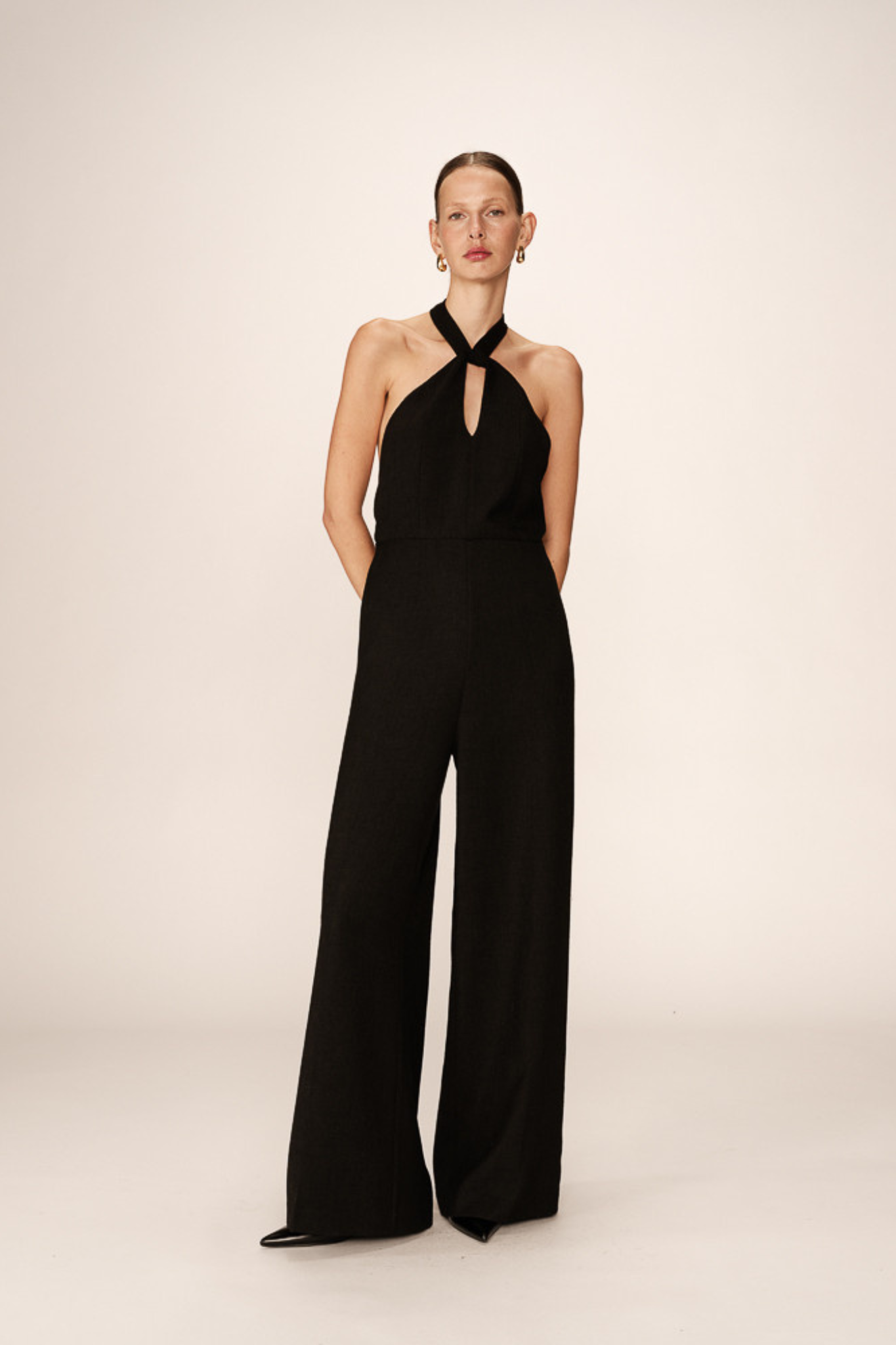 Model wearing the Grace & Mila philomene jumpsuit with open back in black. Front view