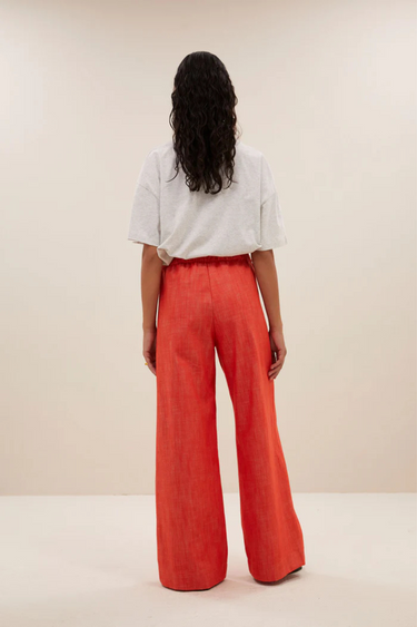 Model wearing the By-Bar Benji twill pants in poppy red. Back view