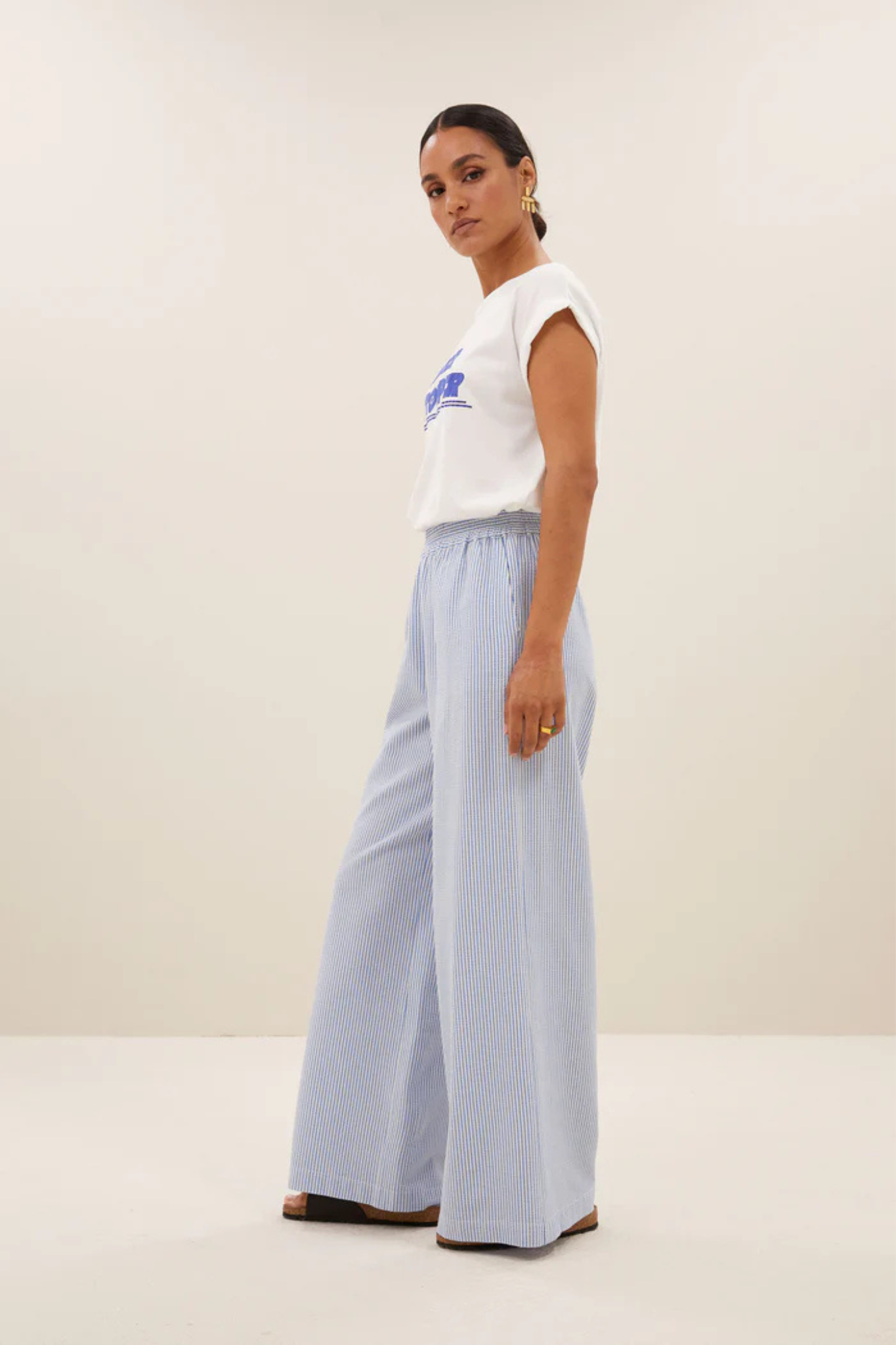 Model wearing the By-Bar randy stripe pants in blue seer stripe. Side view