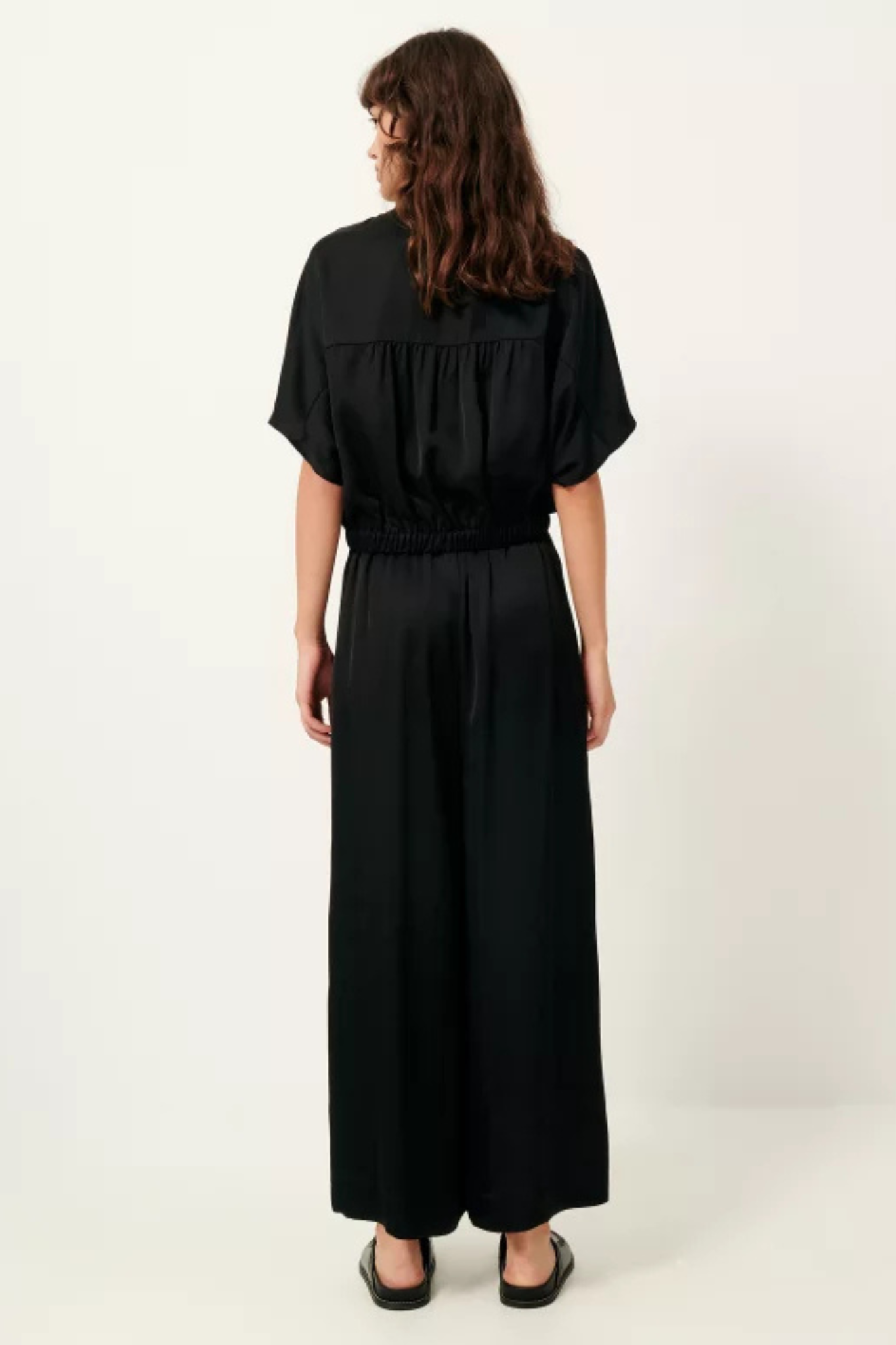 Model wearing the Sessun isla night wide leg elastic pants in black. Back view