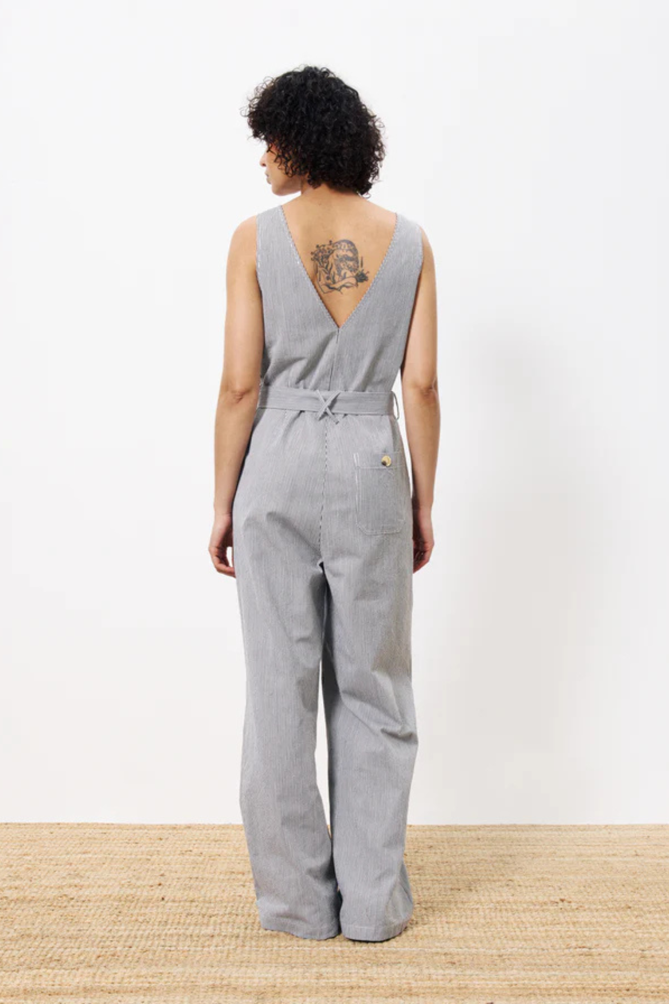 Model wearing the FRNCH maddie jumpsuit in creme. Back view