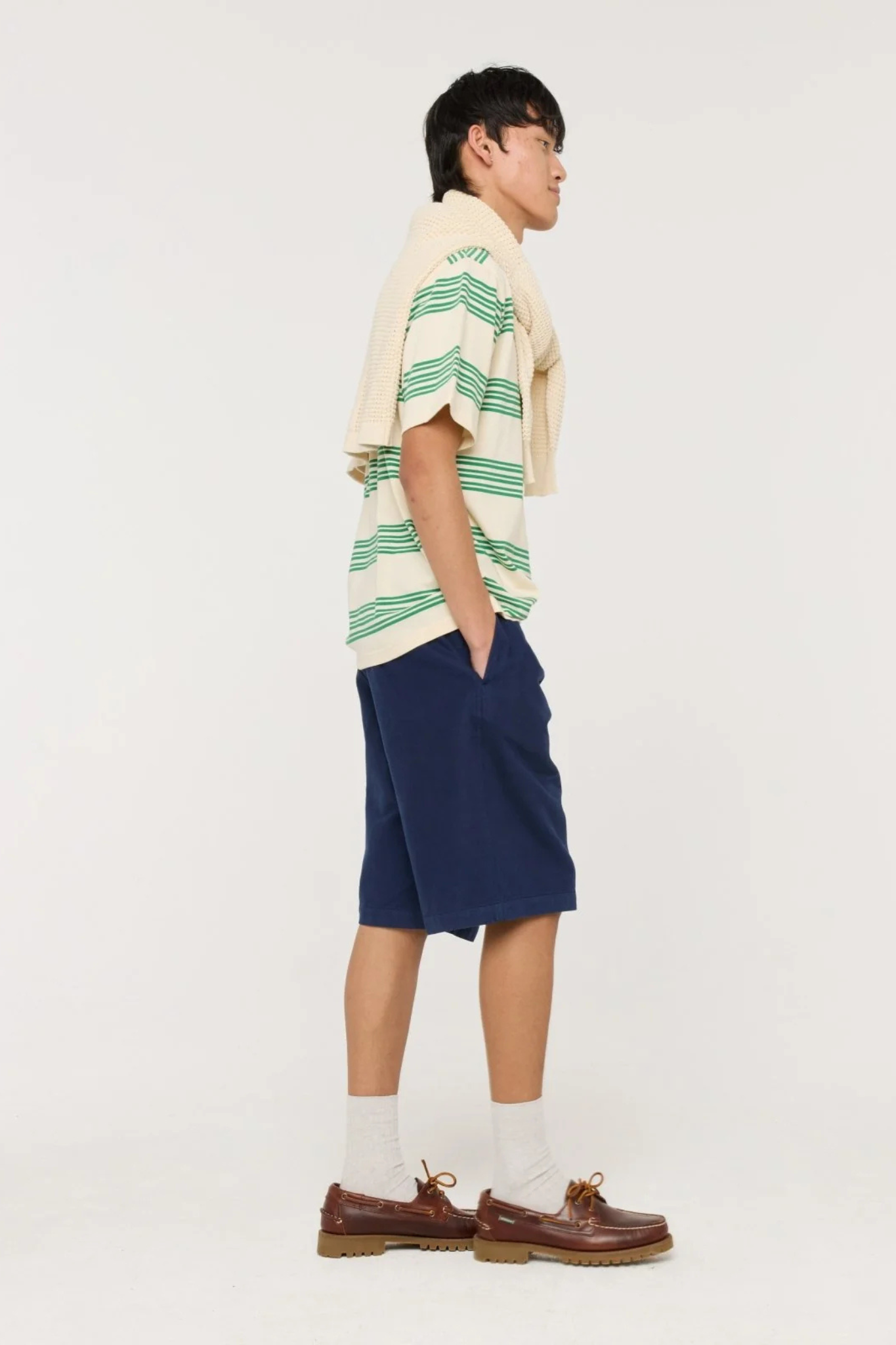 Model wearing the Castart haruto striped t-shirt in green and ecru. Side view