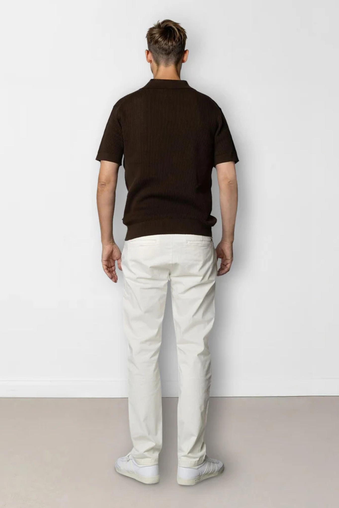 Model wearing the Clean Cut Copenhagen  oliver knitted polo in dark brown. Back view