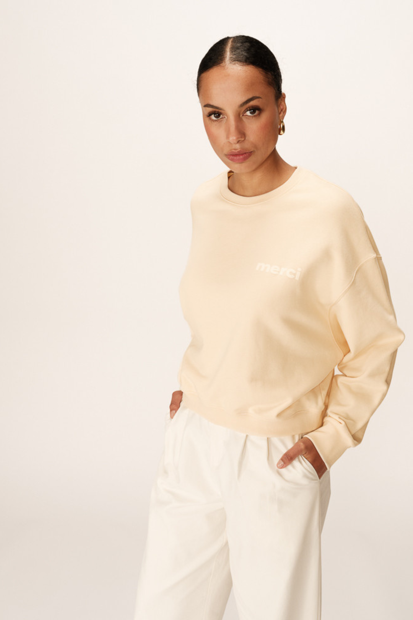 Model wearing the Grace & Mila positive merci sweater in beige. Front view