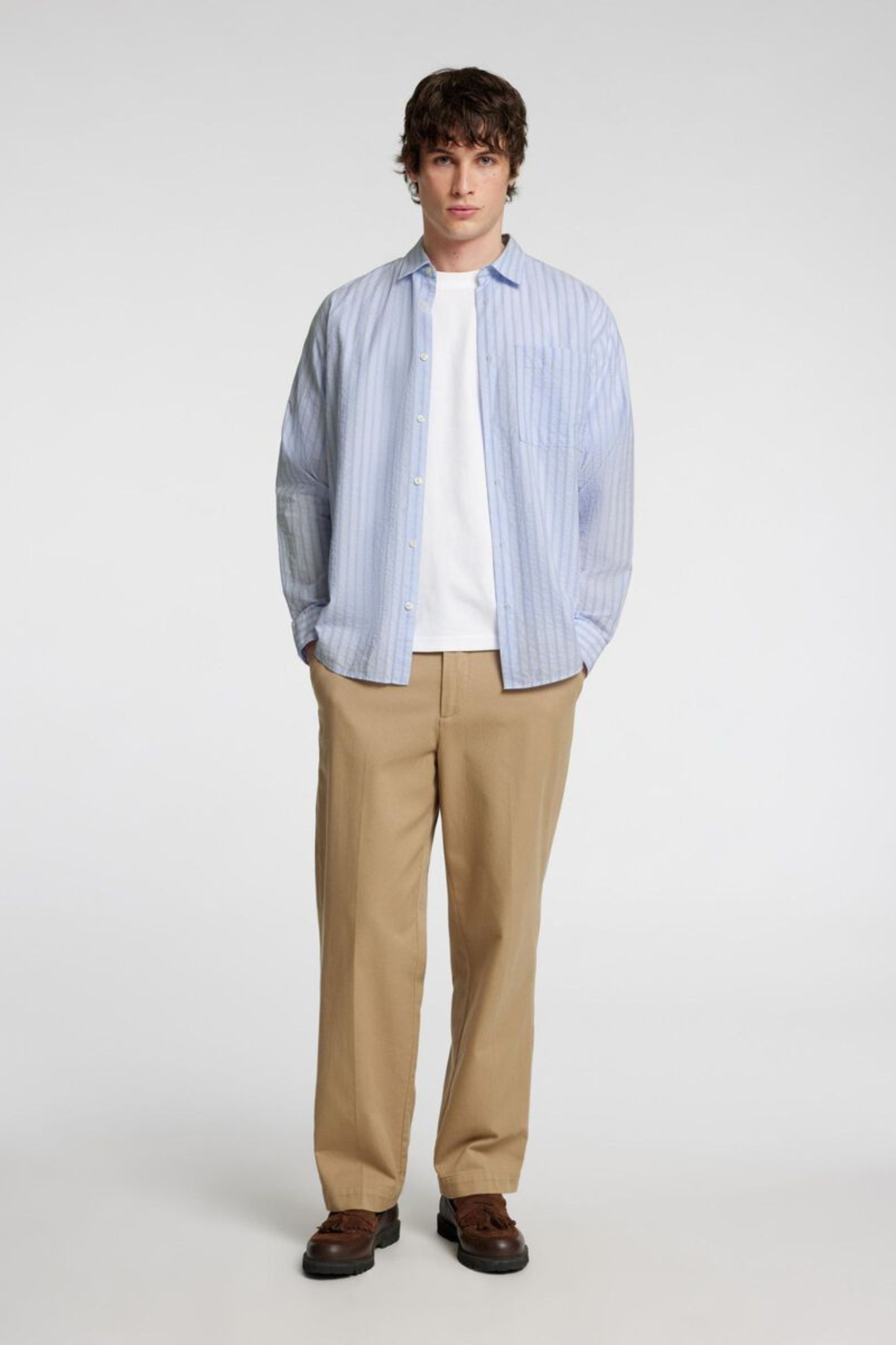 Model wearing the Selected Homme relax wilfred seersucker shirt in blue stripe. Front view