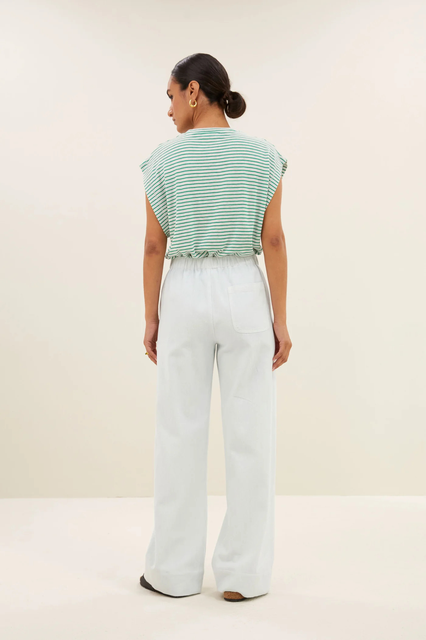 Model wearing the By-Bar mason small stripe top in white and green striped. Back view