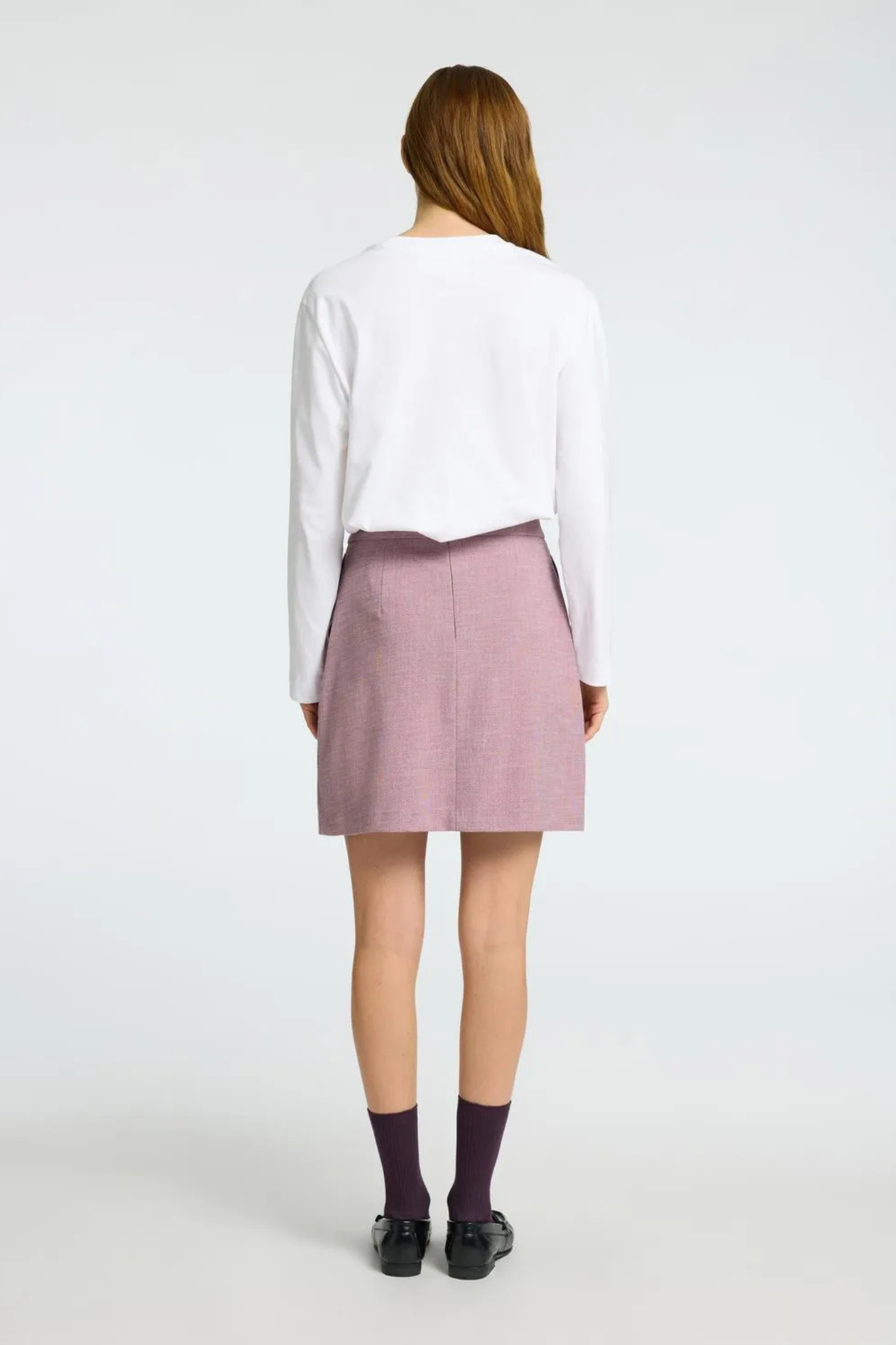 Model wearing the Selected Femme mini skirt in mauve. Back view