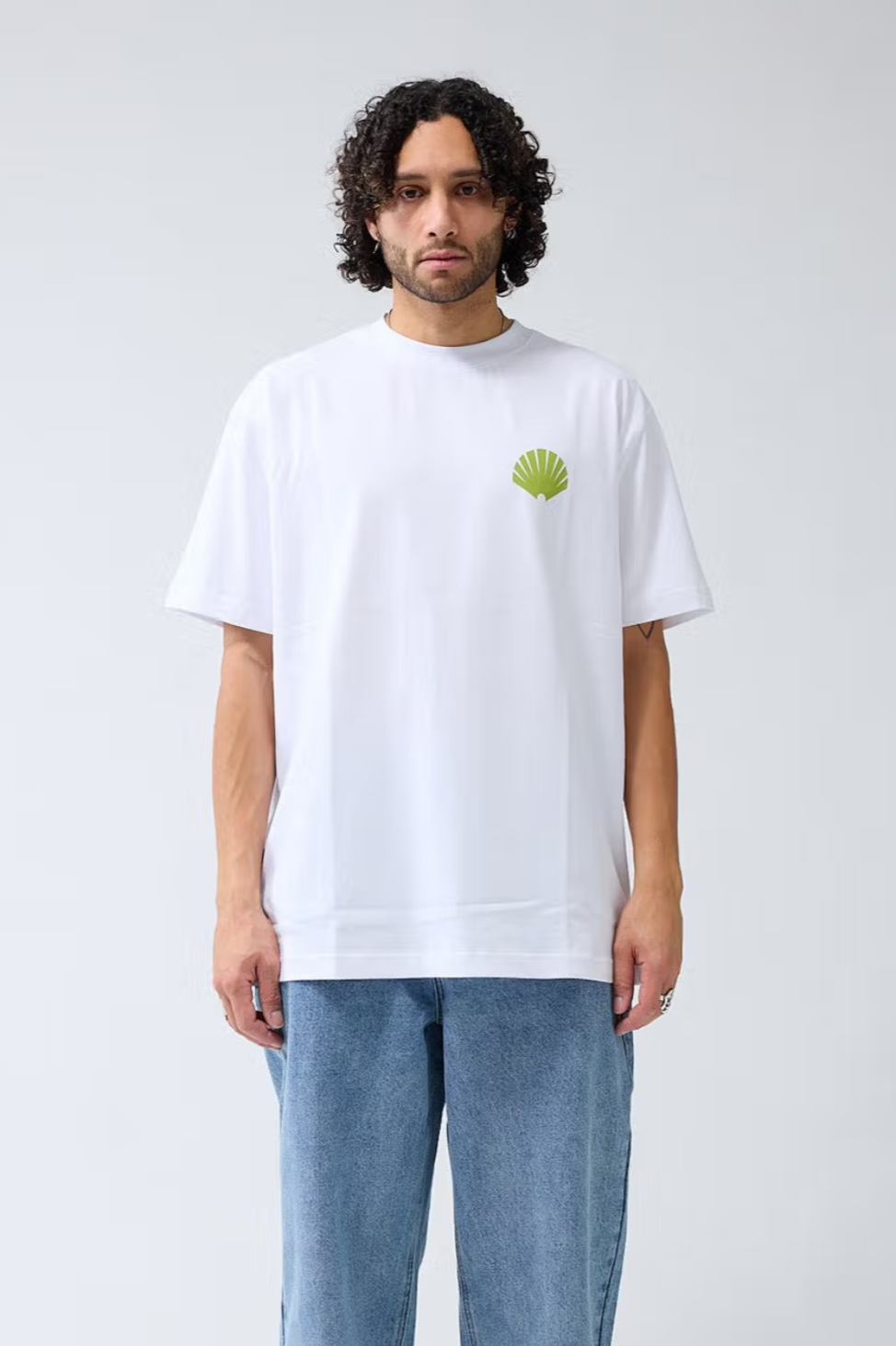 Model wearing the New Amsterdam white logo t-shirt with logo in green. Front view