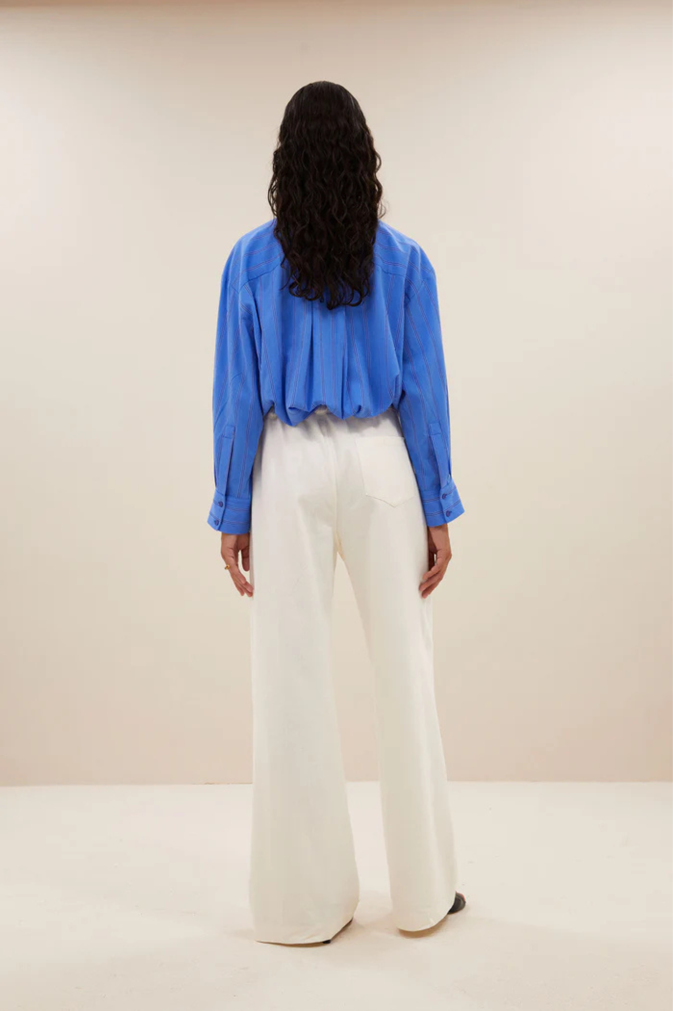 Model wearing the By-Bar nima stripe blouse in blue. Back view