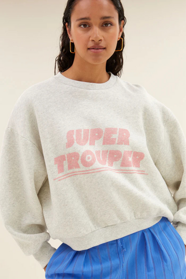 Model wearing the By-Bar grey bibi trouper sweater with letters in pink. Front view