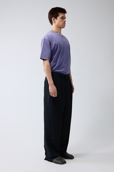 Model wearing the black New Amsterdam wool trousers. Side view