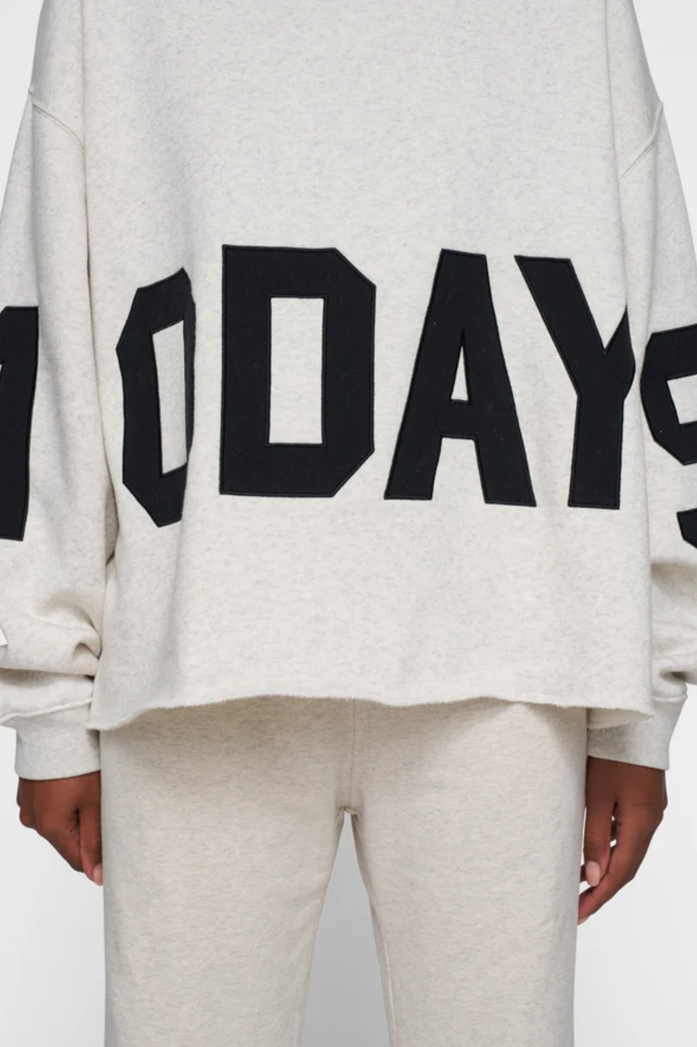 Model wearing the 10DAYS statement logo hoodie in soft white melee. Close front view