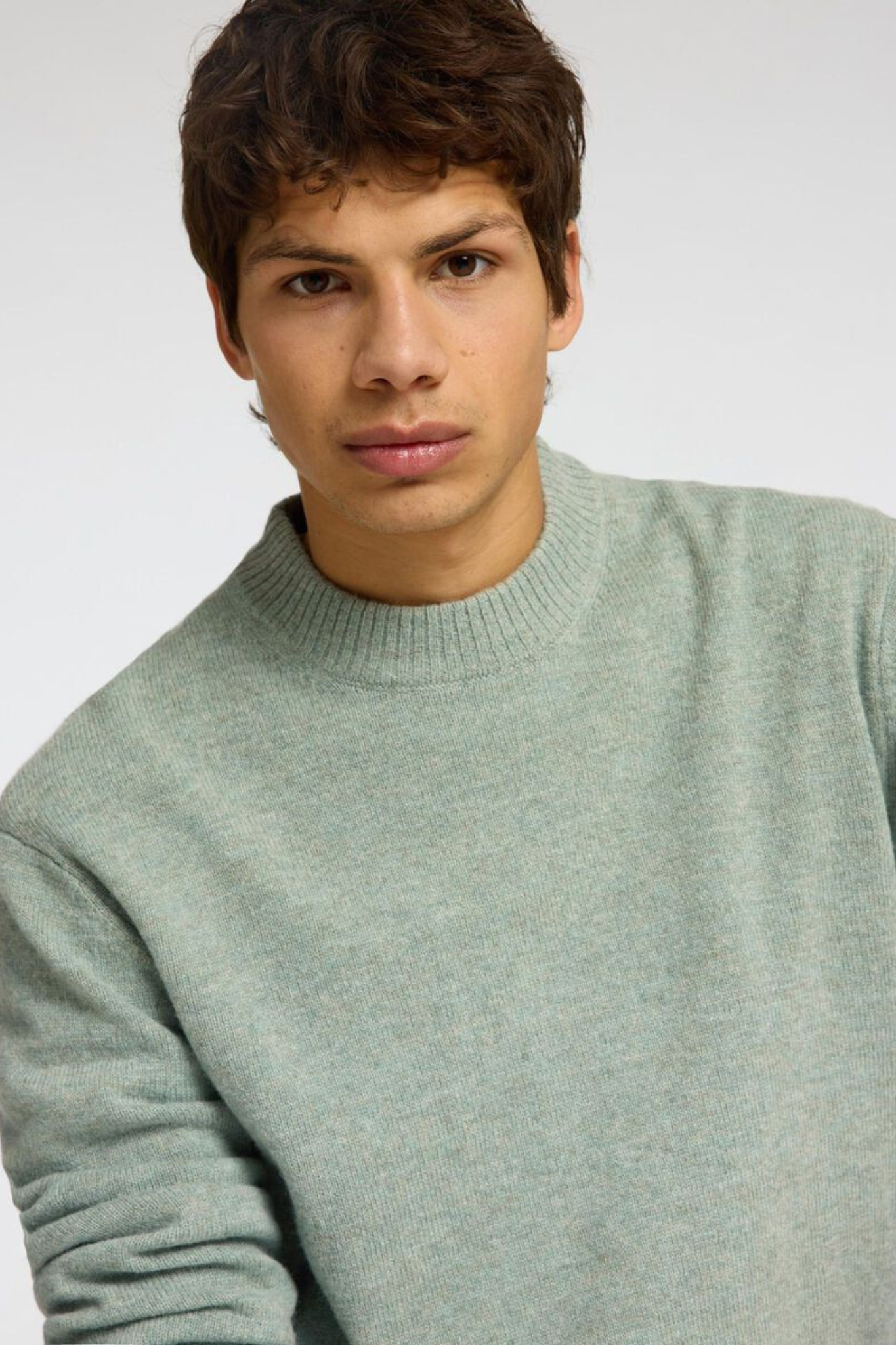 Model wearing the Selected Homme reuben ls knit relaxed crewneck in green. Close front view