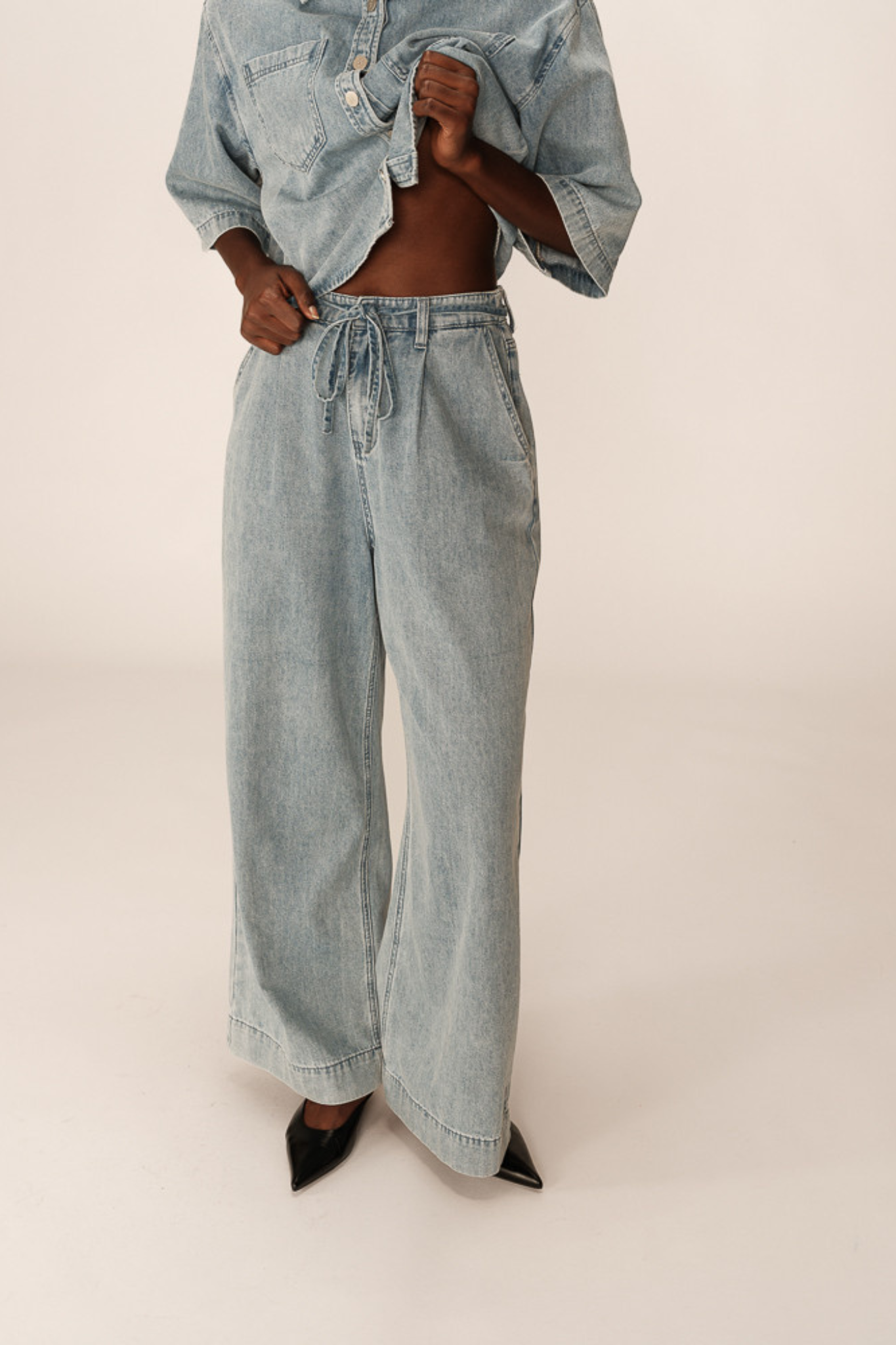 Model wearing the Grace & Mila pompon jeans in denim blue. Front view