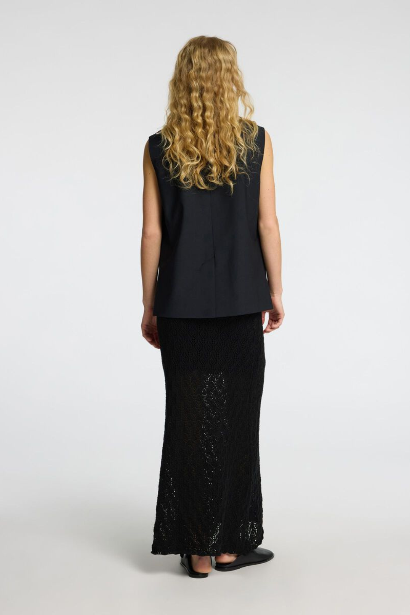 Model wearing the Selected Femme niva hw knit skirt in black. Back view