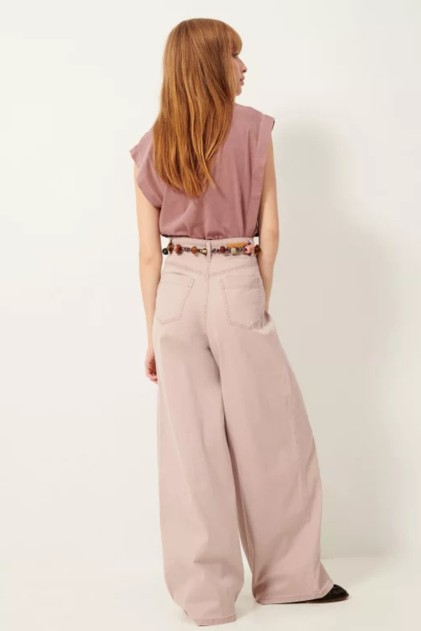 Model wearing the Sessun dalt pants in rustic rose. Back view