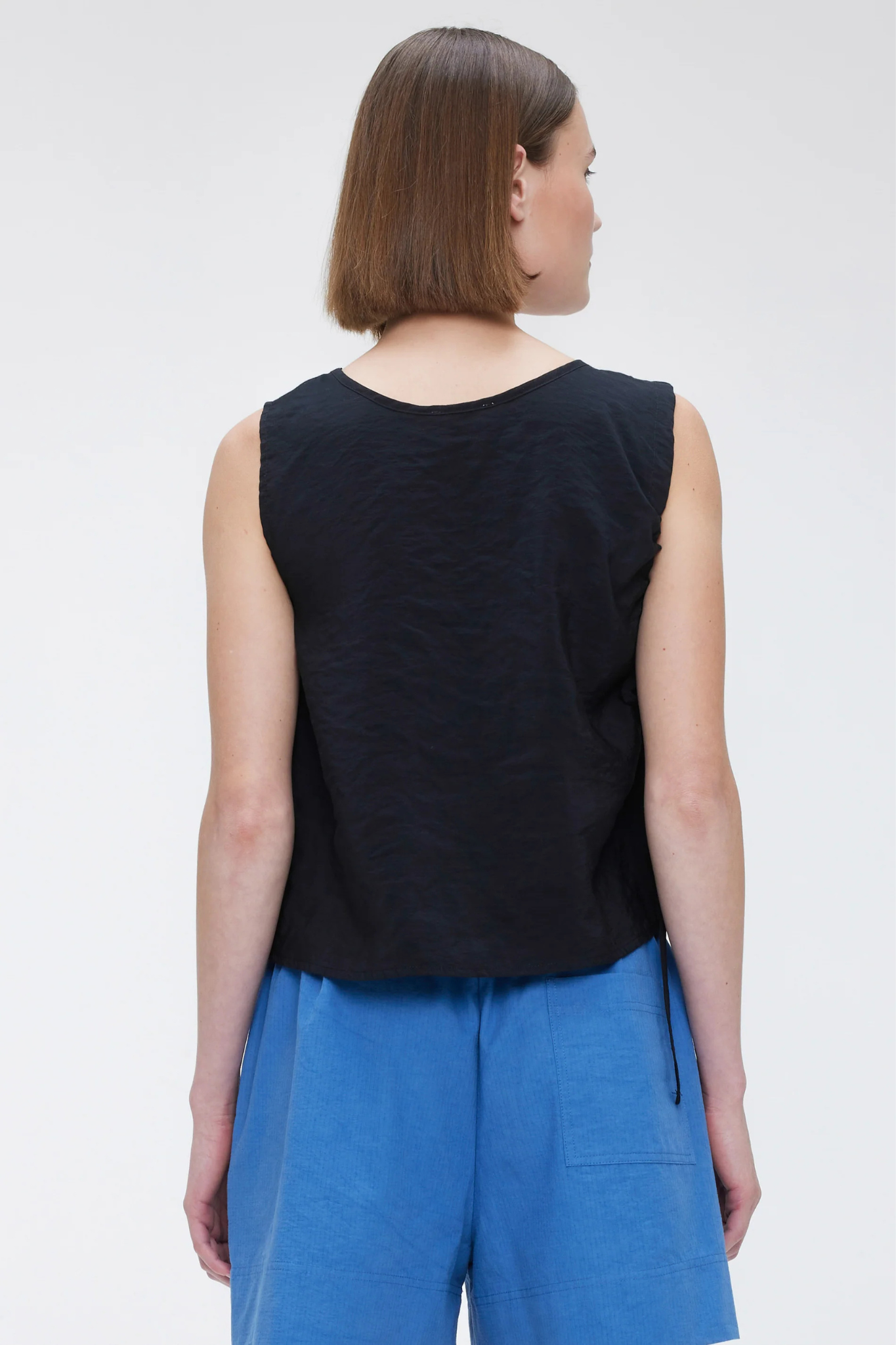 Model wearing the Our Sister toi shirt top in black. Back view