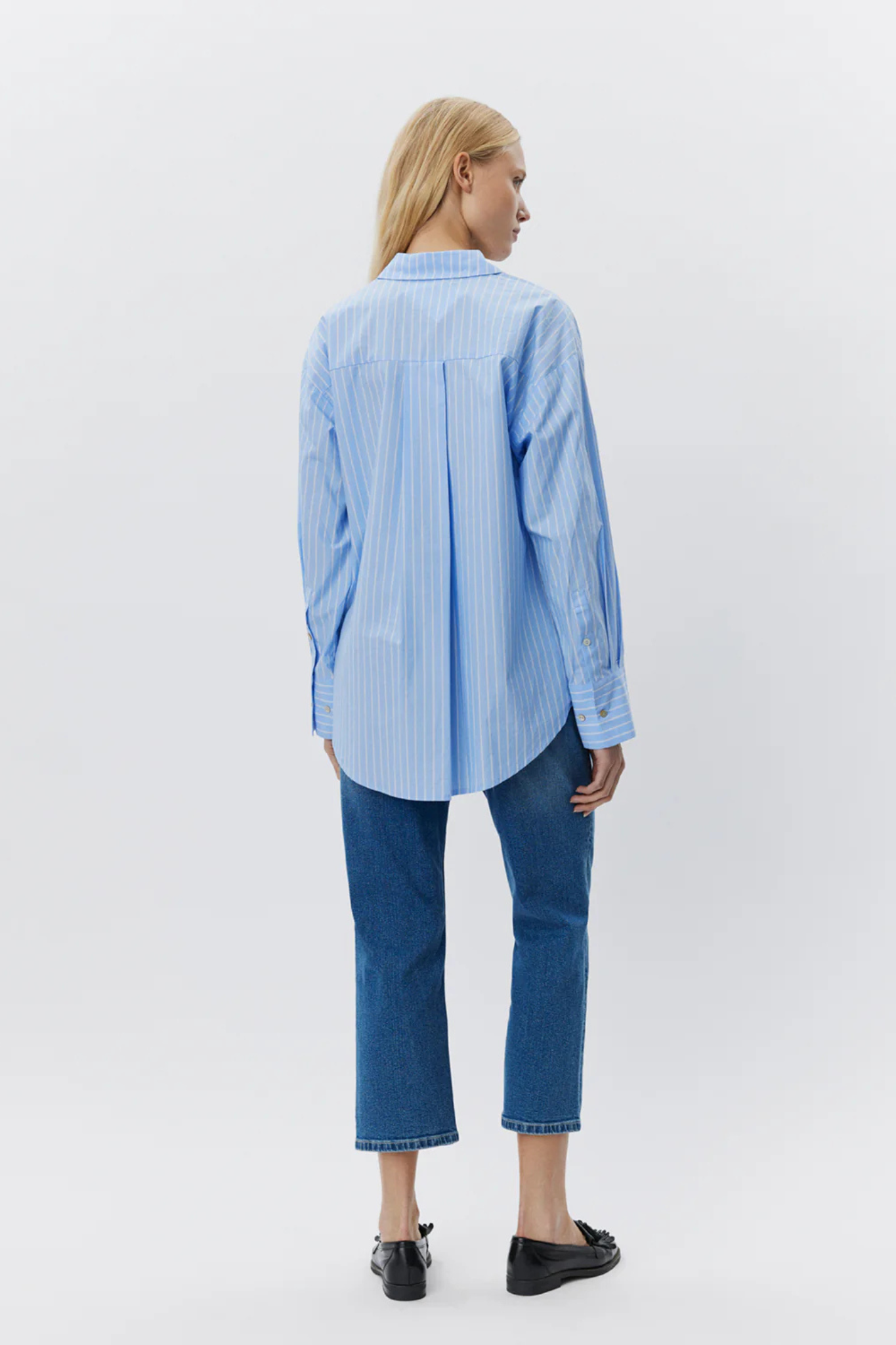 Model wearing the Sofie Schnoor adalene shirt in striped white and blue. Back view