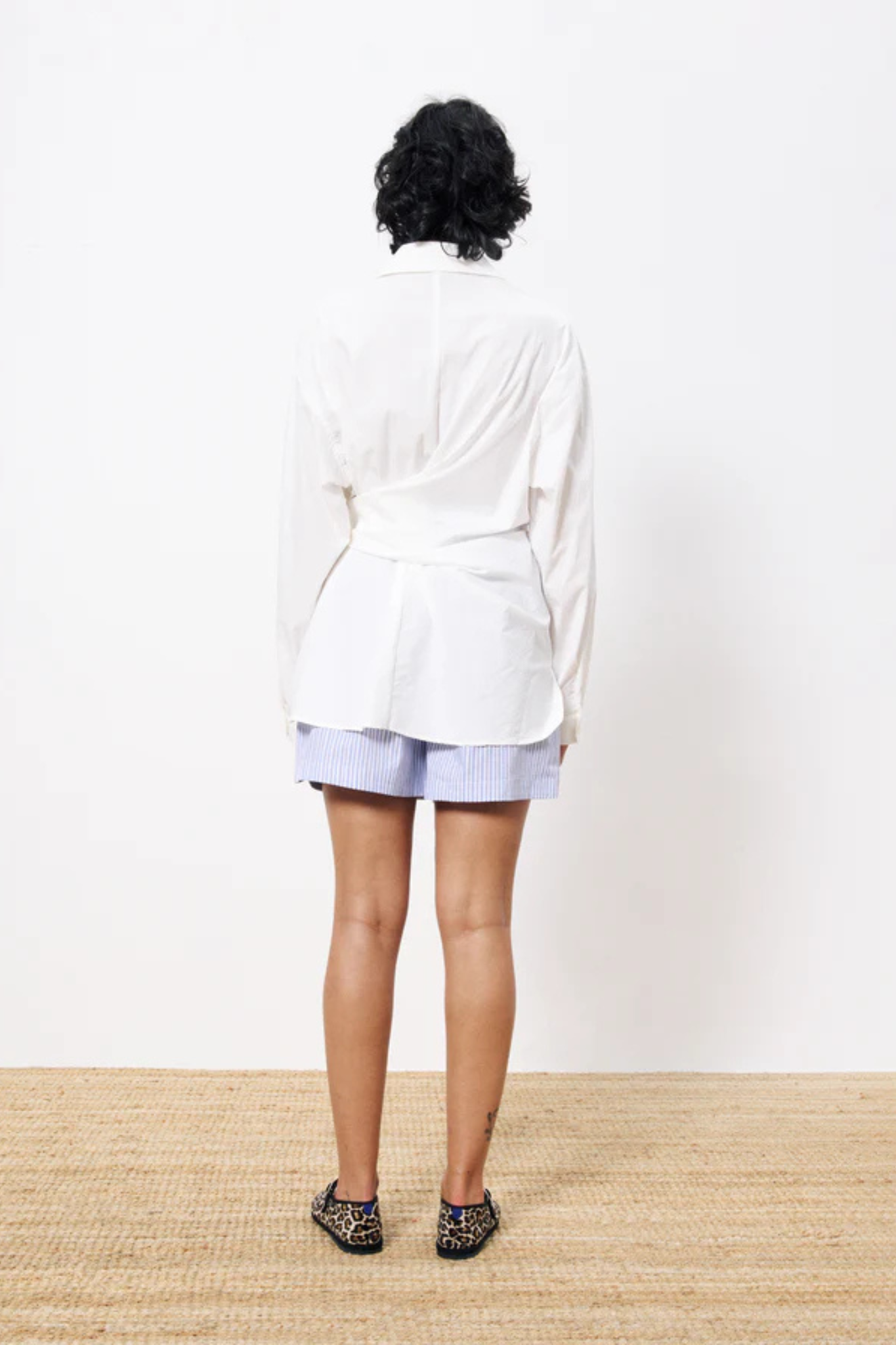 Model wearing the FRNCH adia shirt in white. Back view