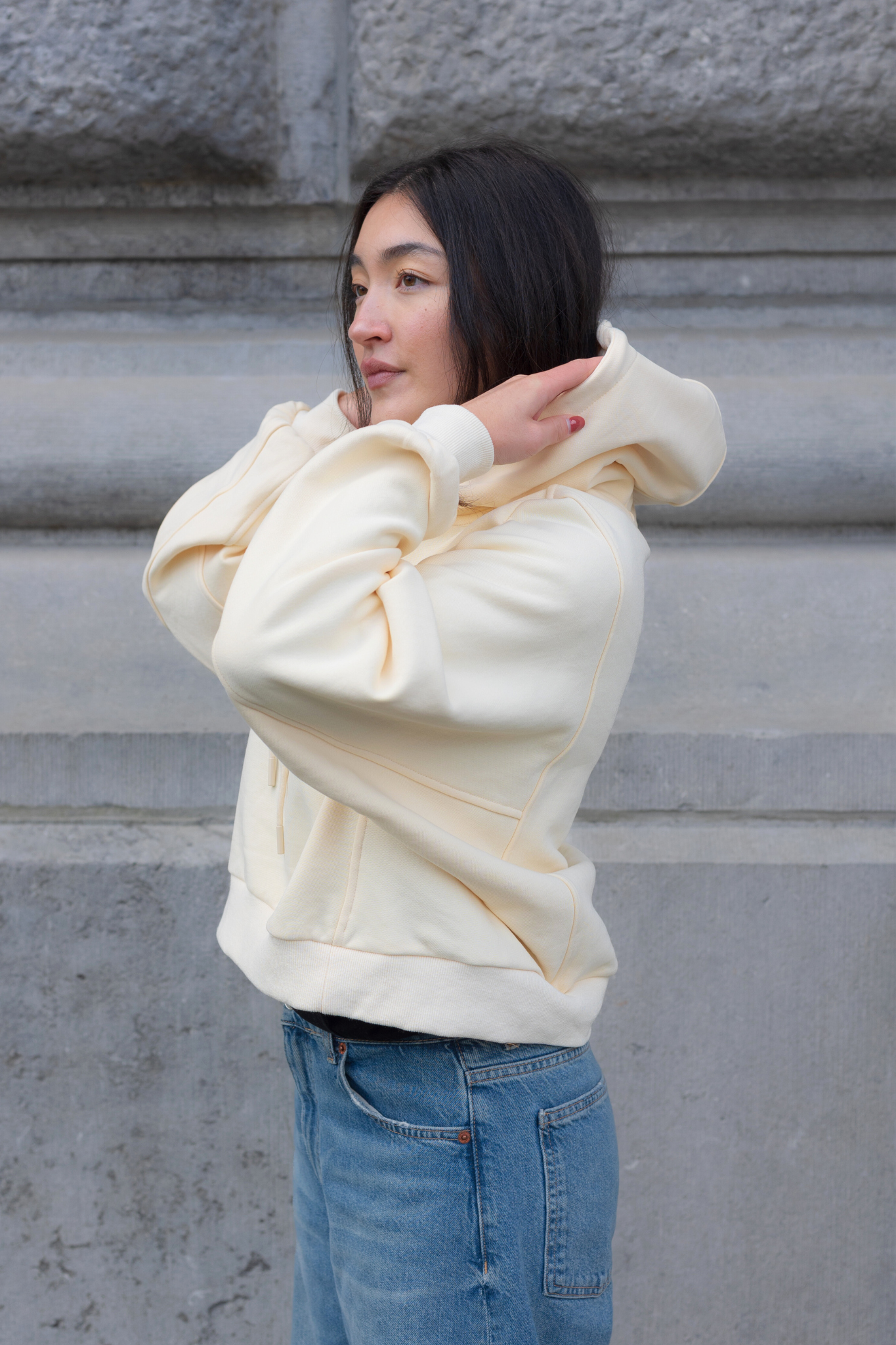 Model wearing the JIJI STUDIOS cathy sweatshirt in creme / yellow. Side view