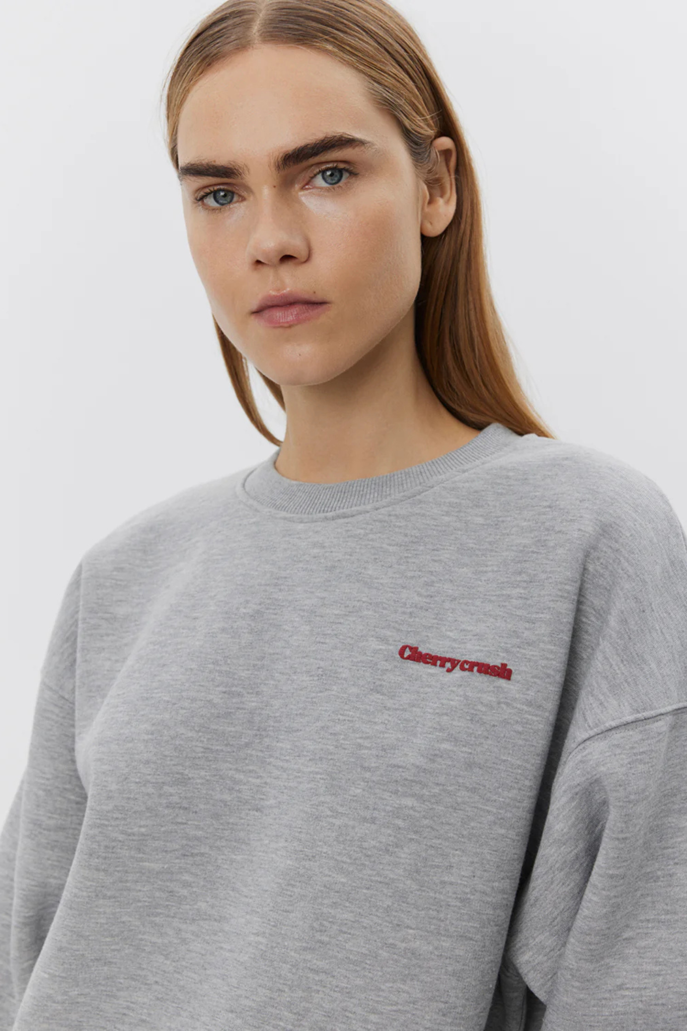 Model wearing the Sofie Schnoor elis sweatshirt in grey melange and cherry graphic in red. Front view