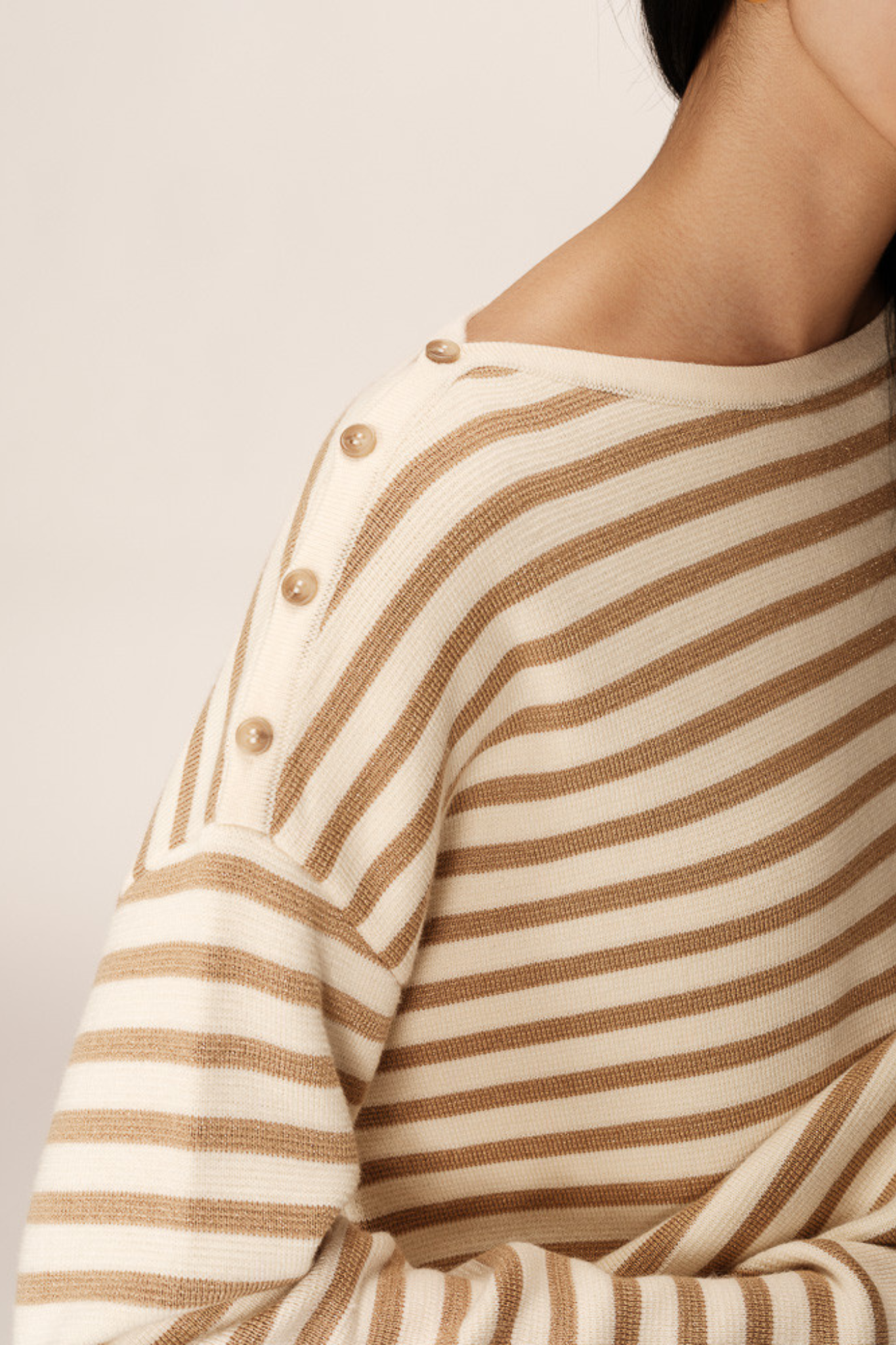 Model wearing the Grace & Mila pachamama sweater in gold and beige. Close shoulder view