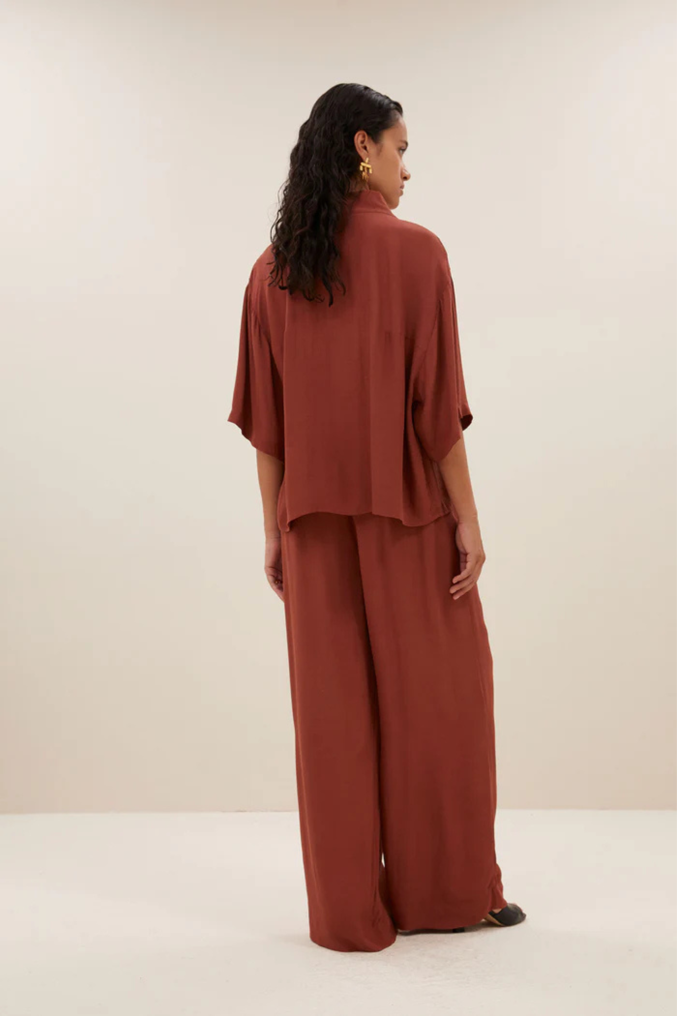 Model wearing the By-Bar owen viscose blouse in brick red. Back view