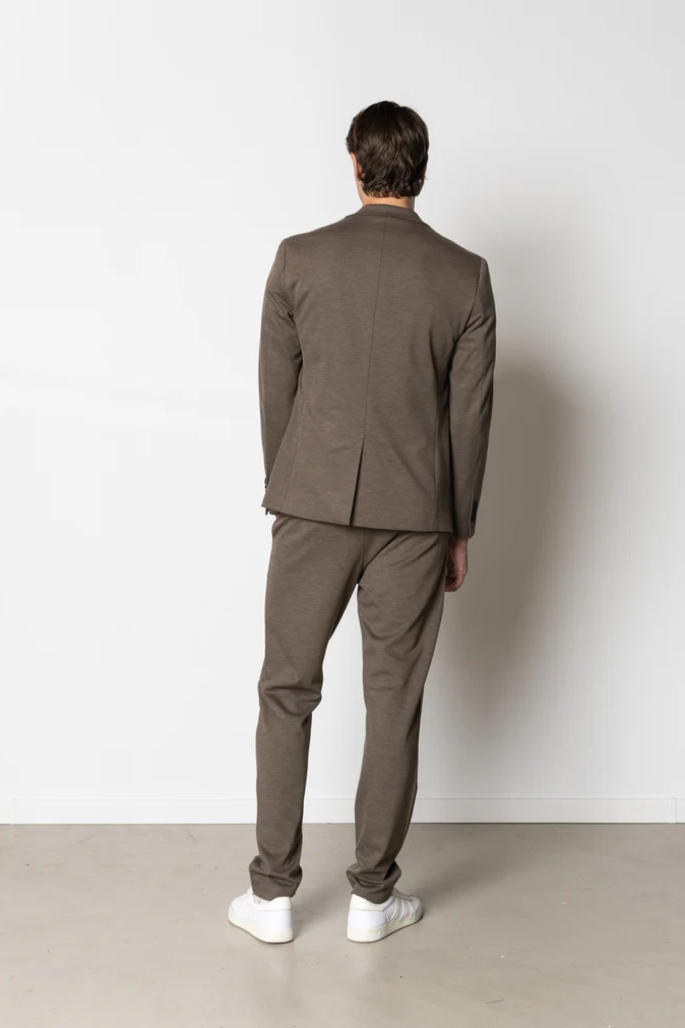 Model wearing the Clean Cut Copenhagen brendon jersey blazer in dark khaki. Back view