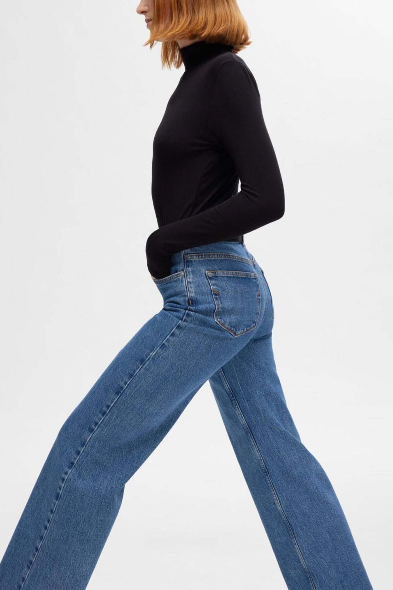 Model wearing the Selected Femme alice jeans hw wide long jeans in light blue denim. Side view