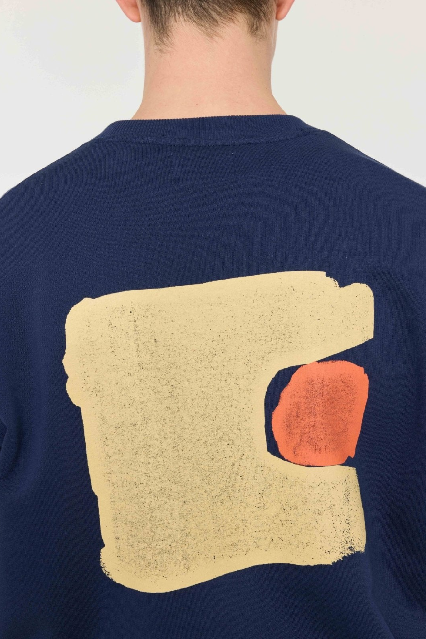 Model wearing the Castart sumo sweatshirt in navy. Back view