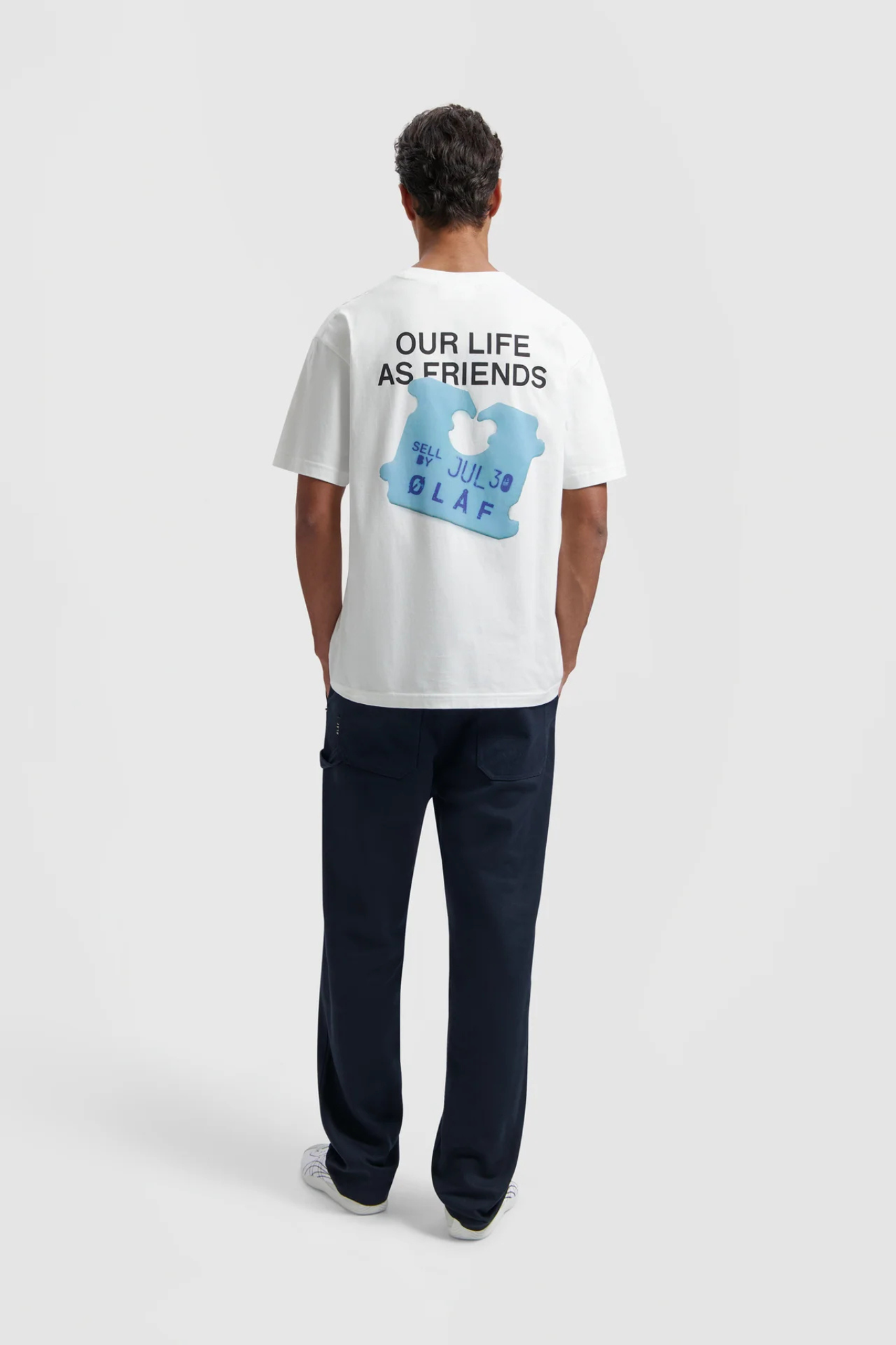 Model wearing the Olaf friends clip t-shirt in white and clip in blue. Back view