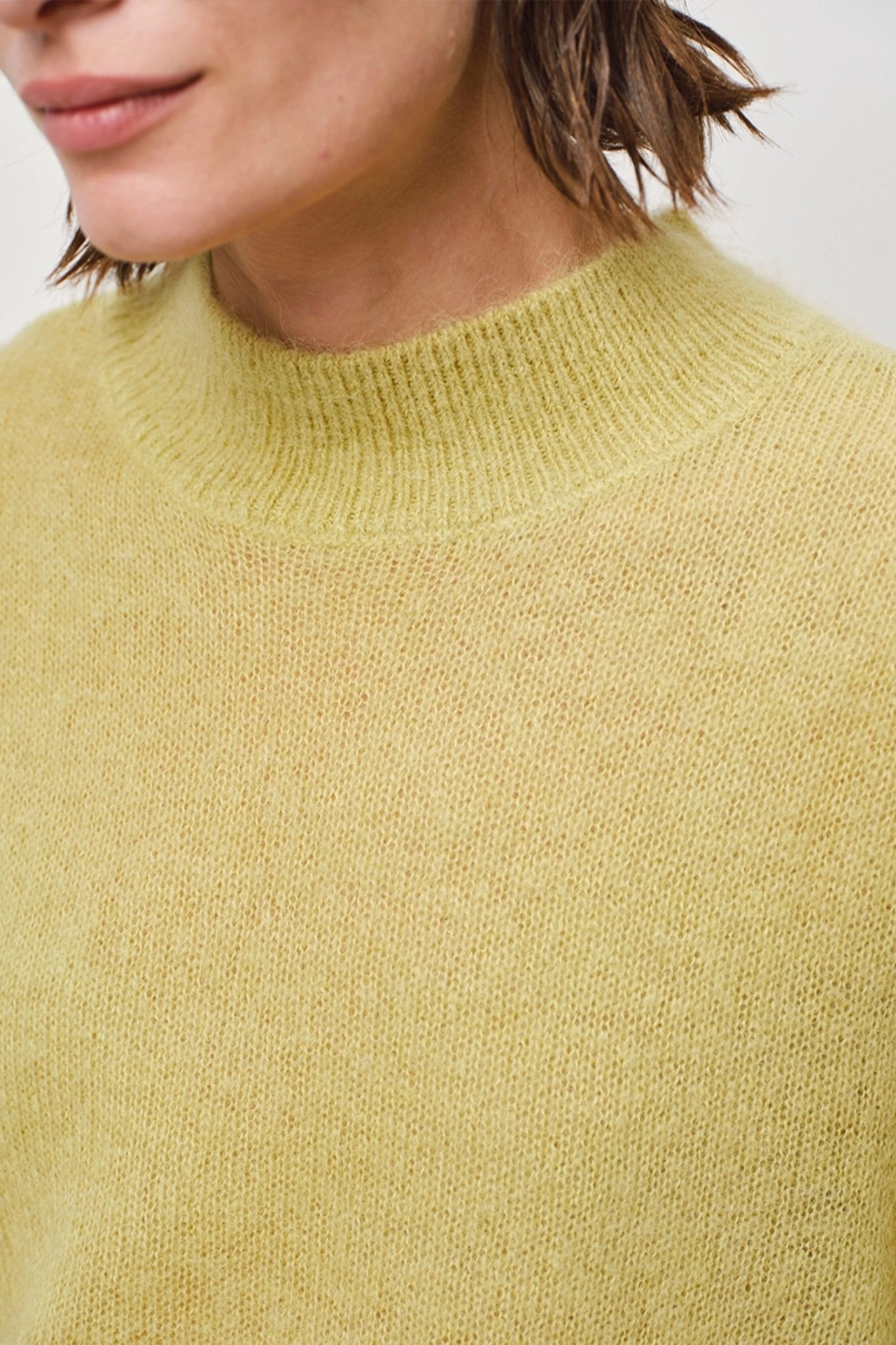 Model wearing the Dante6 aviel open shoulder sweater in lemon grass. Close front view