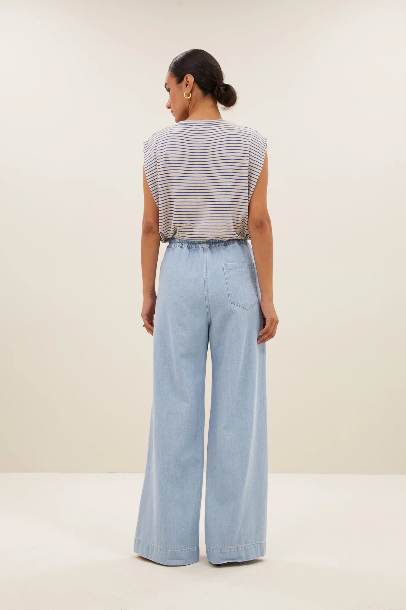 Model wearing the By-Bar diede small stripe top in white and blue striped. Back view