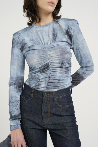 Model wearing the Gestuz areen blouse in blue denim. Front view