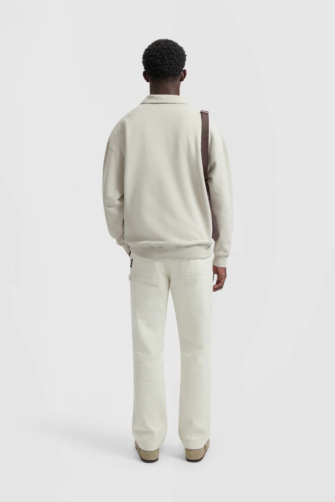 Model wearing the Olaf workwear pants in off-white. Back view