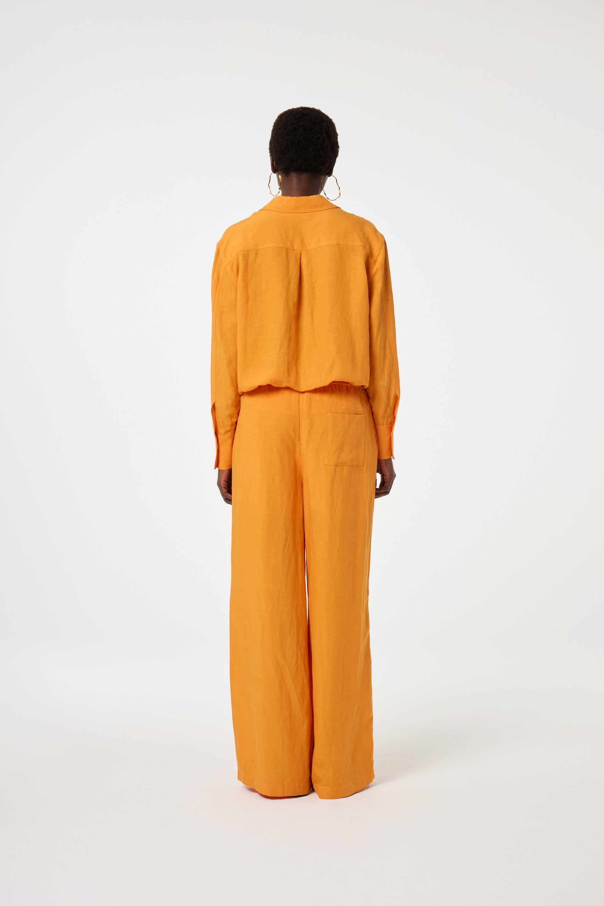 Model wearing the Fabienne Chapot tony blouse in orange. Back view